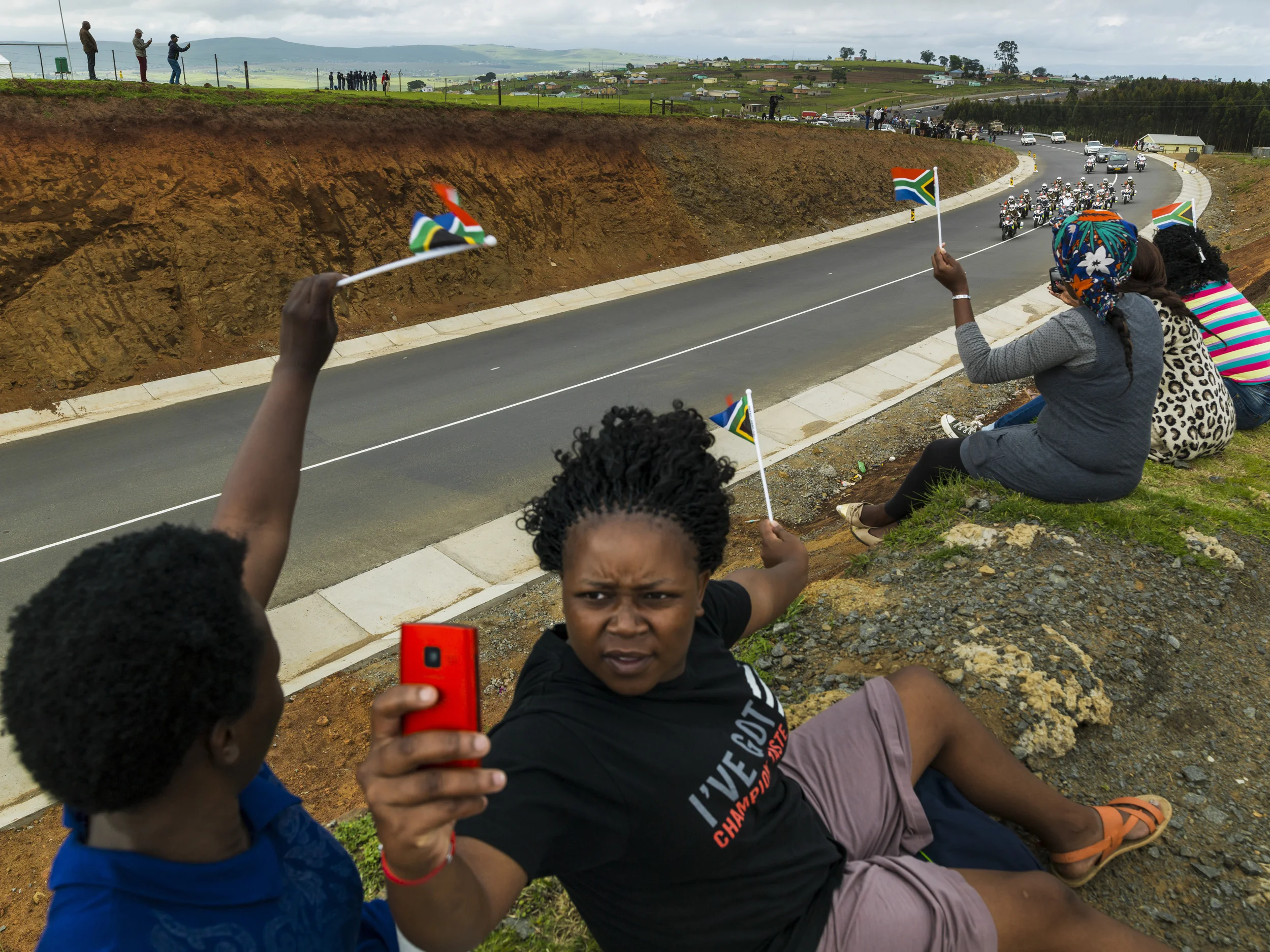 QUNU, EASTERN CAPE, SOUTH AFRICA, 14 DECEMBER 2013: A women takes a selfie as the Nelson Mandela funeral procession appears on the road to Qunu, South Africa, 14 December 2014. An icon of democracy, Mandela was buried at his family home in Qunu afte