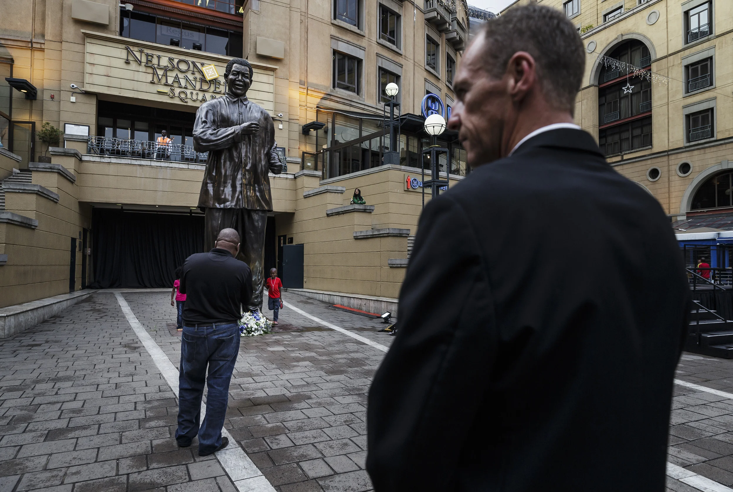 SANDTON, JOHANNESBURG, SOUTH AFRICA, 8 DECEMBER 2013: People pay tribute to the life of Nelson Mandela at Mandela Square in Sandton City shopping center, Johannesburg, 8 December, 2013. There has been a massive response the death of Nelson Mandela a