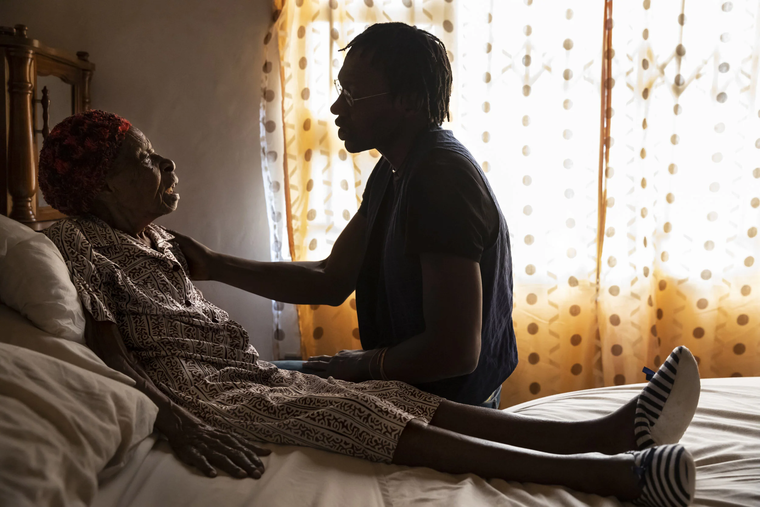 HARARE, ZIMBABWE, 28 JANUARY 2020: Dixon Chipanda, psychiatrist and founder of NGO Friendship Benches, visits with his grandmother who he says was part of his inspiration for the benches project. Friendship Benches uses a network of grandmothers who