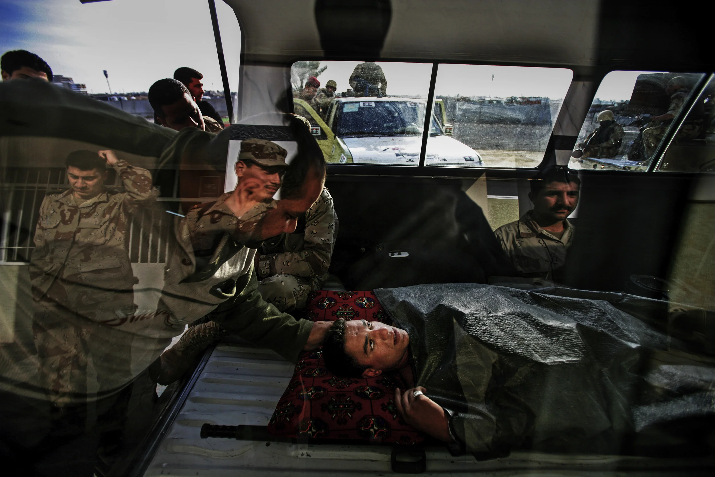 BAGHDAD, IRAQ - 17 FEBRUARY 2005: Iraqi National Guard member Ali Nadim, 20, is rushed to hospital after being wounded by grenade attack during a firefight in the Haifa street area of Baghdad. These Iraqi National Guard members have been trained by