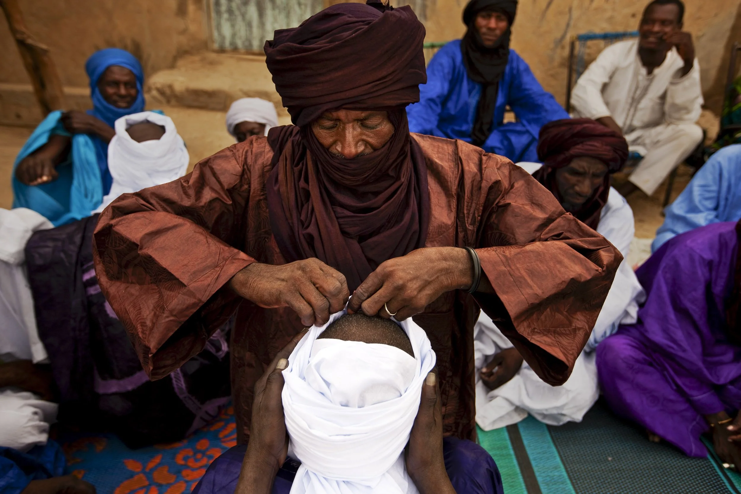TIMBUKTU, SEPTEMBER 2009: Two young men go through the Tuareg Chesh ceremony where each is ceremonially turbanned in front of their families by an elder man, Timbuktu, 20 September 2009. This signifies their coming of age and elegibility to marry an