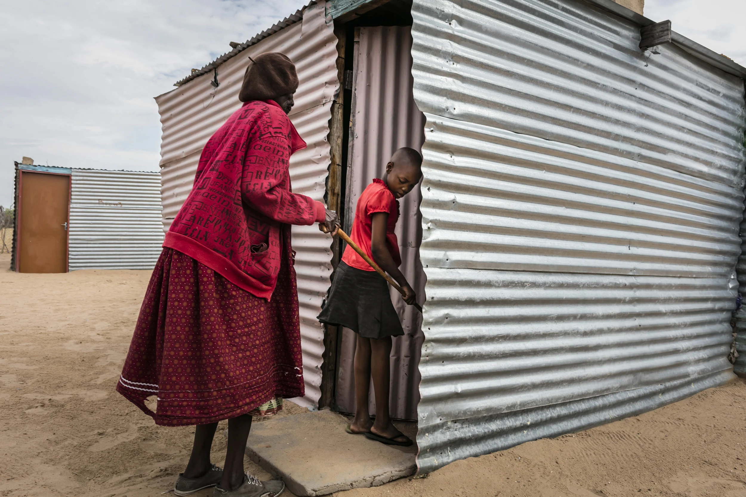 OHANGWENA DISTRICT, NORTHERN NAMIBIA, 8TH NOVEMBER 2015: Lusina Nghitotelwa helps to guide her blind grandmother Lucia on her way to the bathroom close to the family compound in Ohangwena, Namiba. For millions of people around the world blindness is