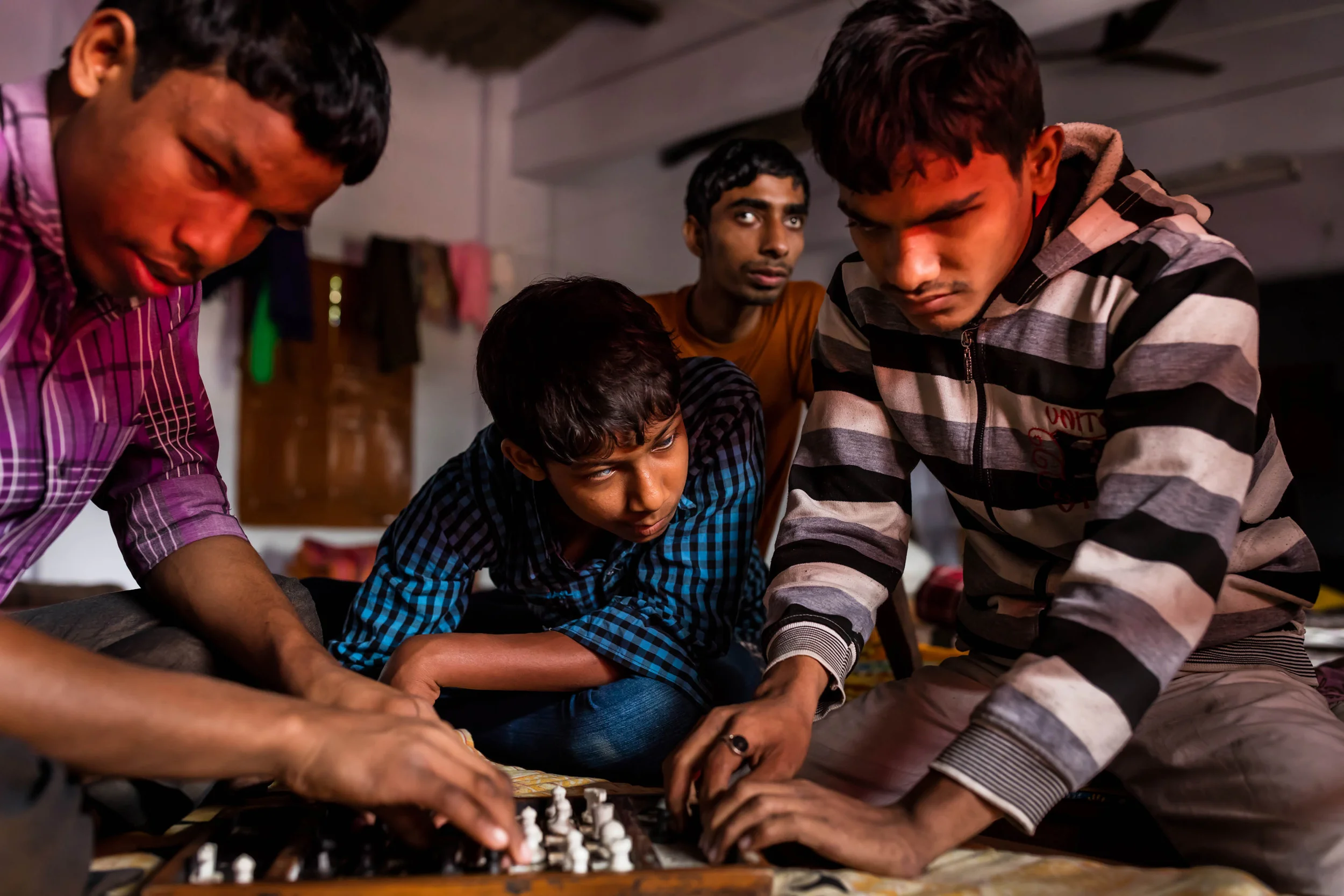 VIVEKANANDA MISSION ASRAM, HALDIA, WEST BENGAL, INDIA, JANUARY 14, 2016: Blind boys play chess in their dorm room in the hostel residence of the Vivekananda Mission Asram school for the blind. The game requires extraordinary memory skills for a blin