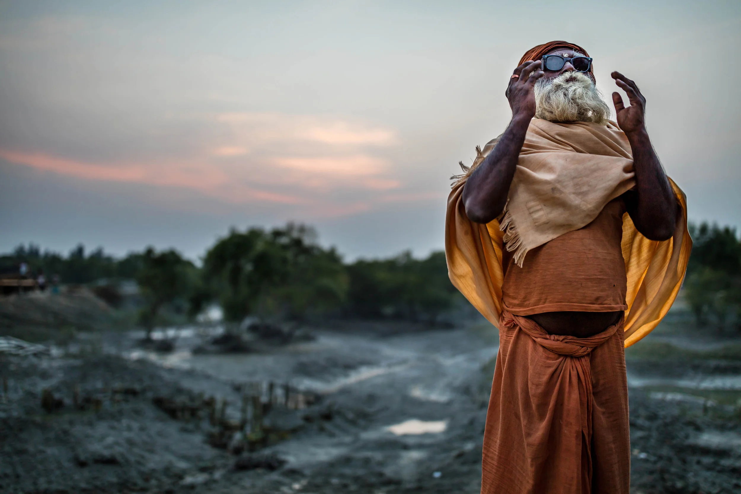 SUNDARBANS, WEST BENGAL, INDIA, 10 JANUARY 2016: Satish Goswani, a Hindu priests poses for a portrait on his way home after temple. He is wearing proctive glasses he received after recent eye surgery made possible by a local NGO working in the remot