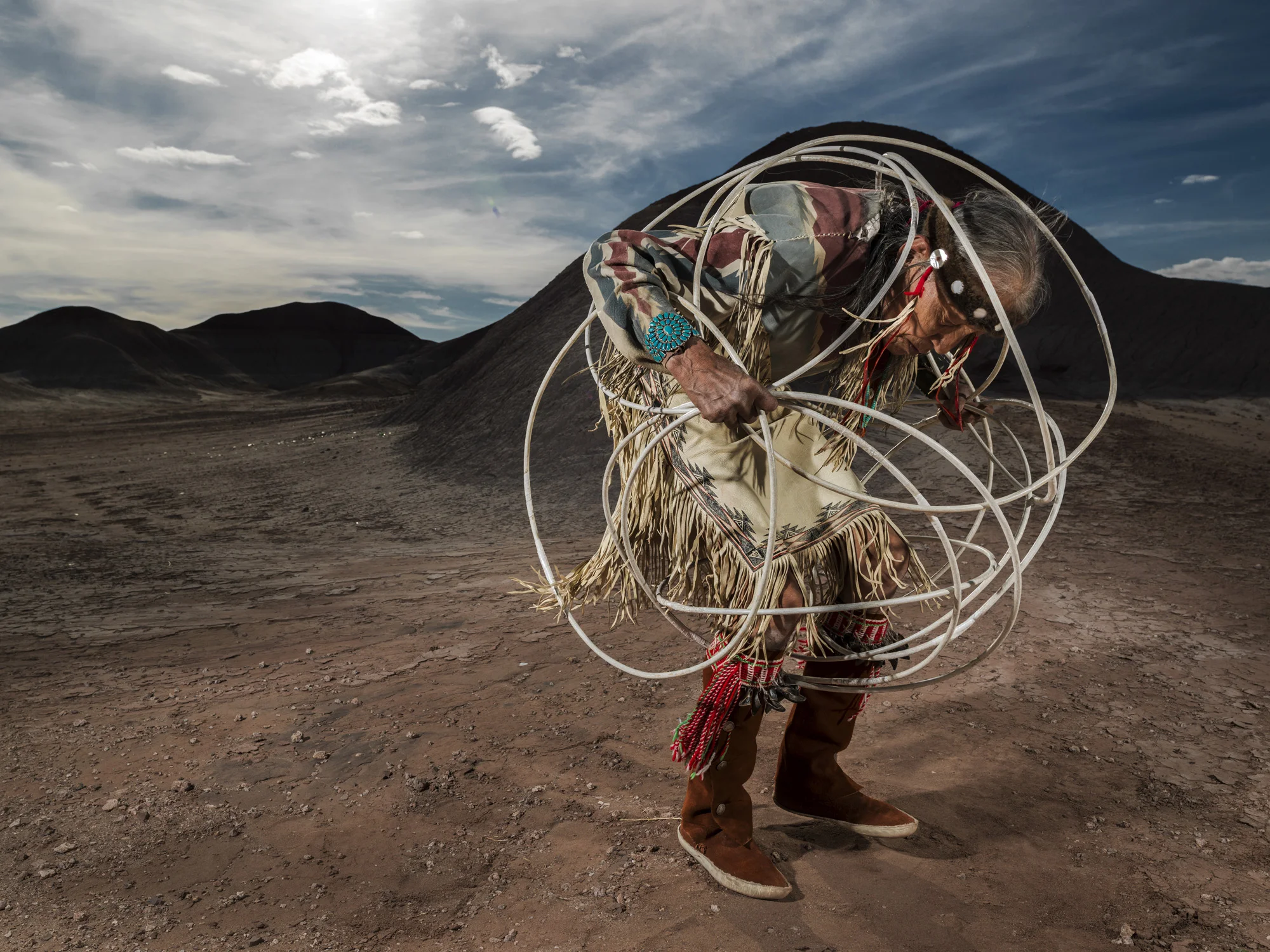 CAMERON, ARIZONA, 16 APRIL 2014: Jones Benally, a famous medicine man, dances the Navajo Hoop dance in a small canyon in the badlands of Cameron, Arizona. The hoop dance is traditionally performed at the end of a grueling nine day ceremony and is a