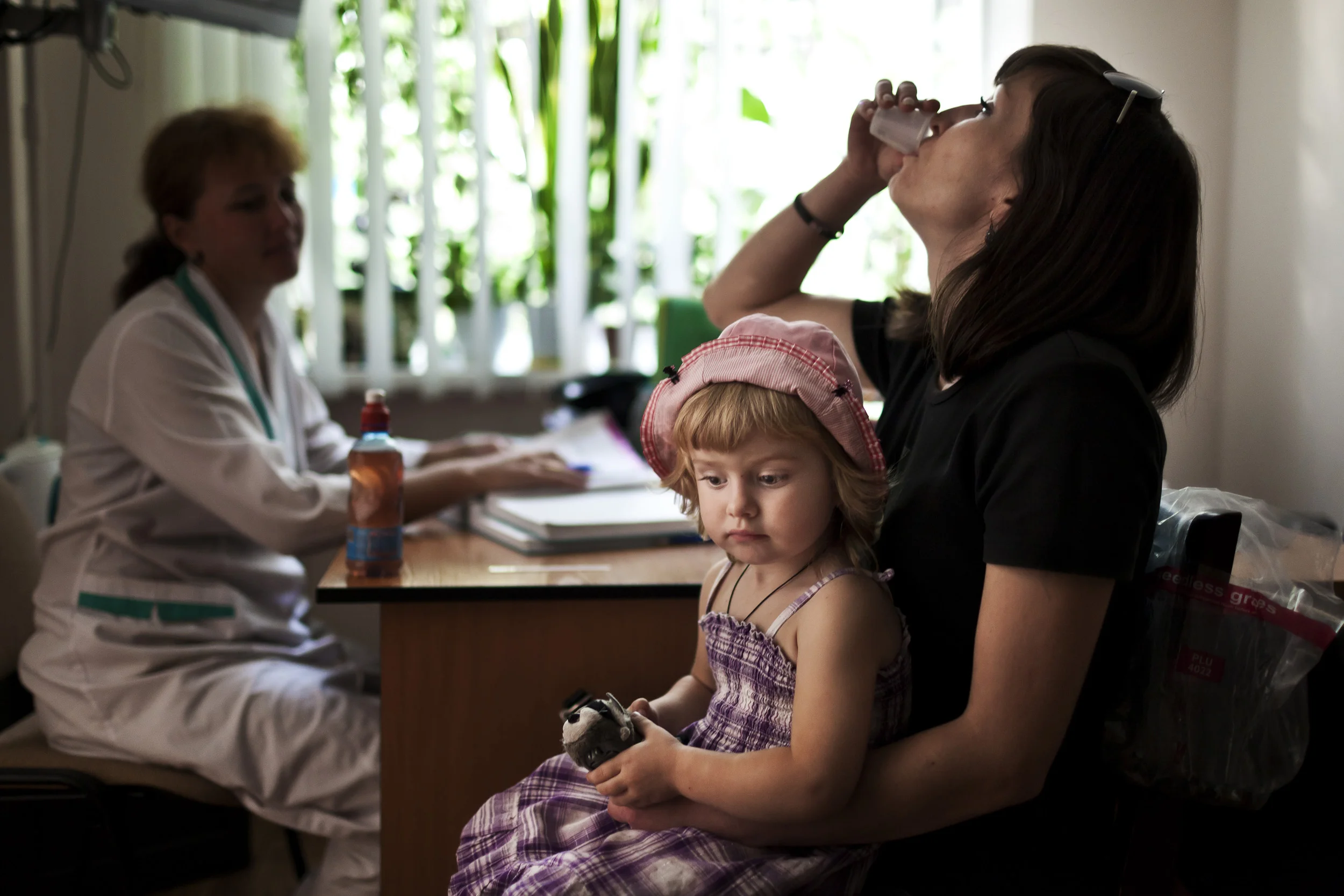 KIEV, UKRAINE, AUGUST 2011: An HIV+ mother swallows her Methadone dosage at a drug substitution program using Methadone to substitute for Heroin at the Kiev Aids Center in Kiev, Ukraine, 25 August 2011. This program has been treated with suspicion b