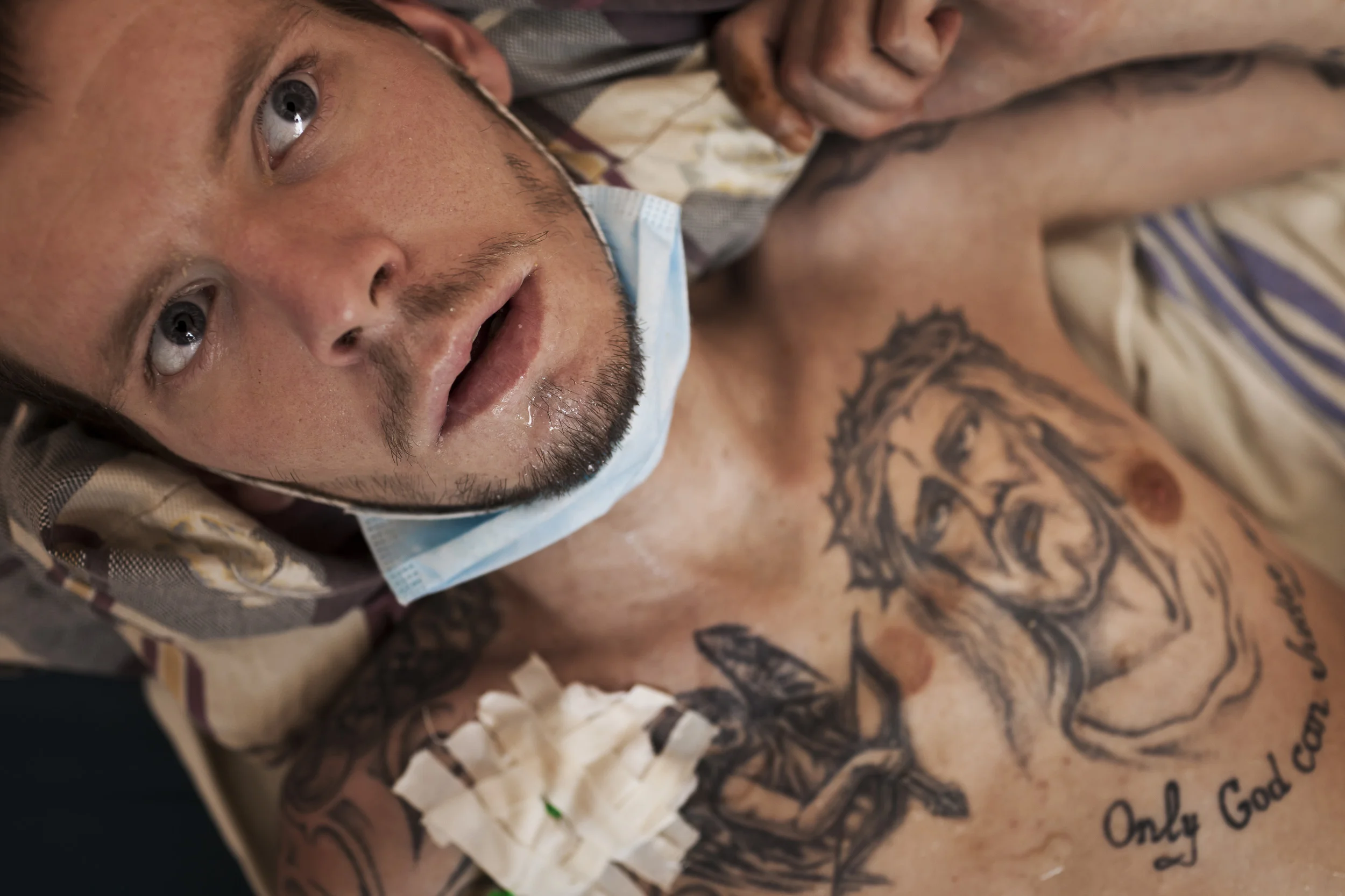 KIEV, UKRAINE, AUGUST 2011: A prisoner n the last stages of full-blown Aids who has been rushed to the Kiev Aids Center from prison receives compassionate care from a doctor while chained to the bed, The Kiev Aids Center in Kiev, Ukraine, 25 August