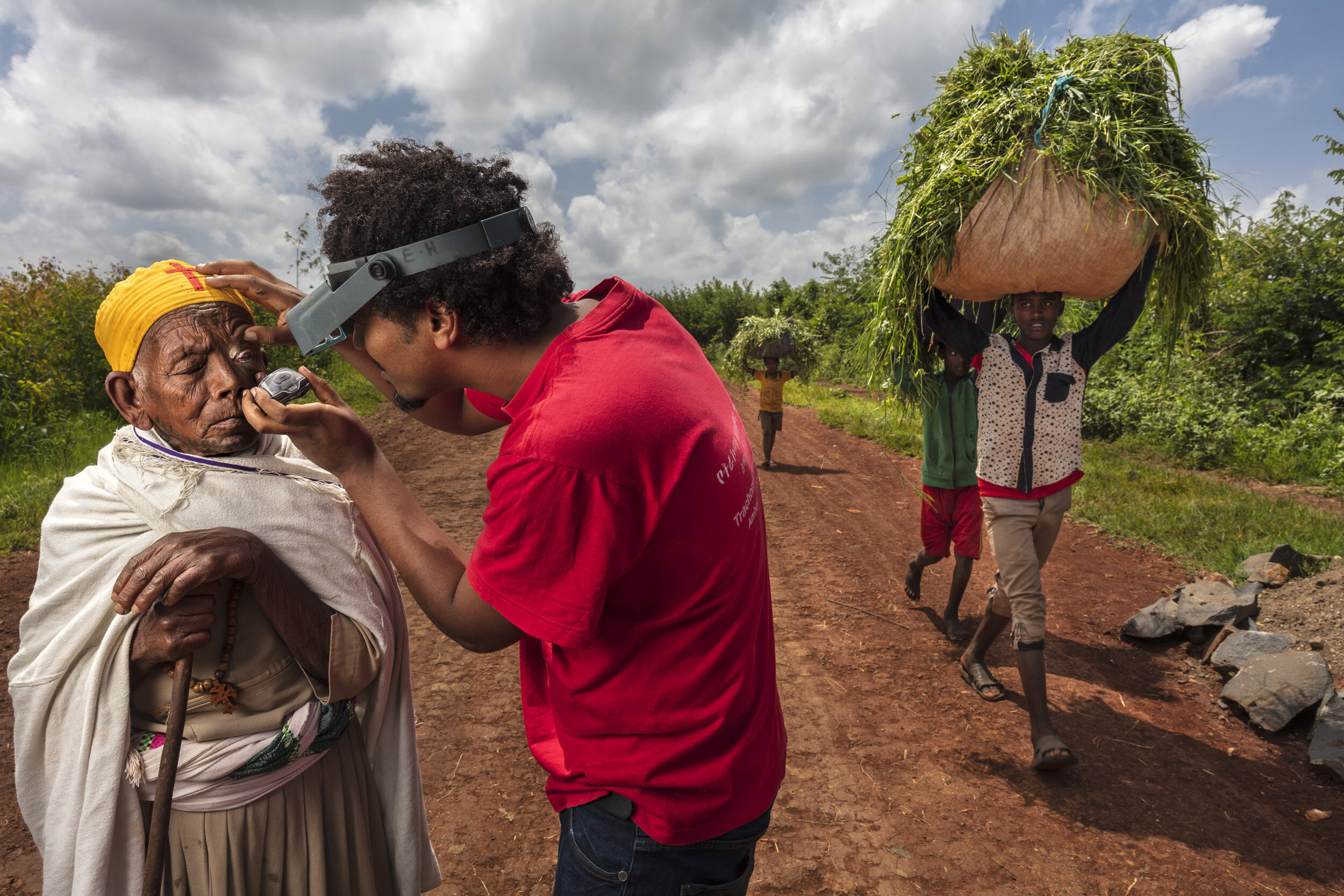 Esmael Habtamu from The Carter Center for Trachoma Control Program is seen checking an elderly lady for signs oftrachoma in North Mecha Woreda, Amhara region of Ethiopia. The Amhara region is the most endemic area inthe most endemic country. Tracho