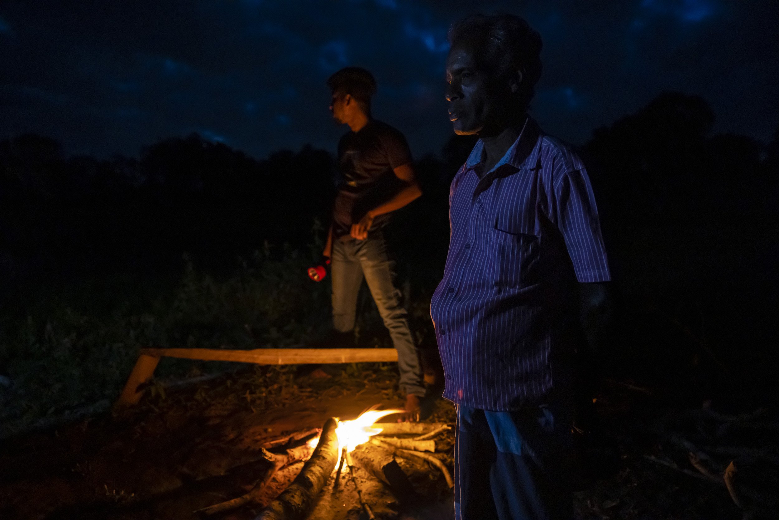 GALGAMUWA, SRI LANKA, 28 JUNE, 2022: Village men prepare to spend the night on elephant watch in their rice paddies close to the border region of the Kahalla Pallawa nature reserve. This area has many elephant and the border region runs up against c