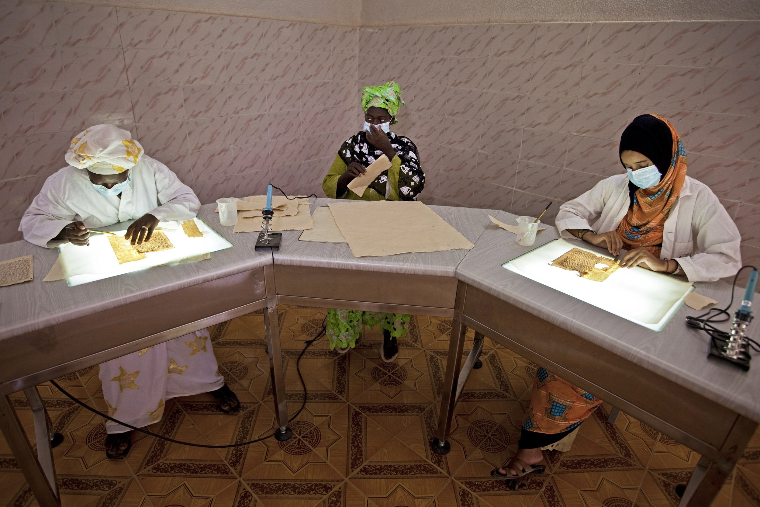 TIMBUKTU, SEPTEMBER 2009: Local women restore ancient manuscripts at the Mama Haidara Centre Juma Almajid Pour La Conservation et la Restauration des Manuscripts A Tombouctou, September 7, 2009. Timbuktu is a historical Malian city, a long establi