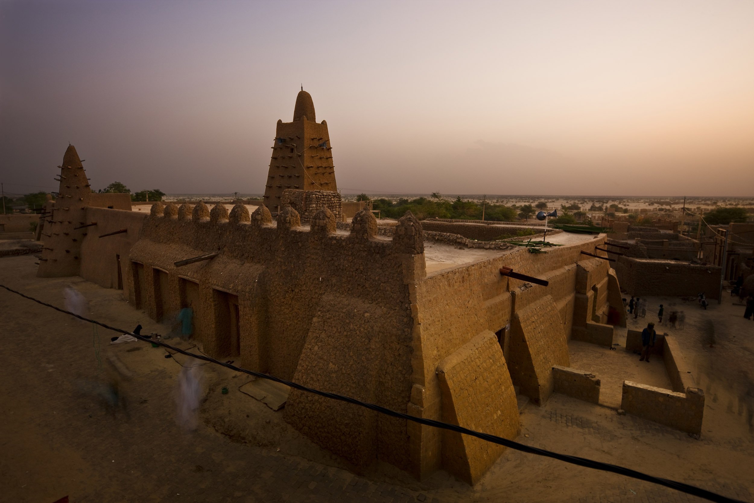 TIMBUKTU, SEPTEMBER 2009: The Djingareiber Mosque, Timbuktu's oldest and most important Islamic place of worship, seen during Ramadan and with the desert sands clouding the air behind it, September 6, 2009. Timbuktu is a historical Malian city, a l