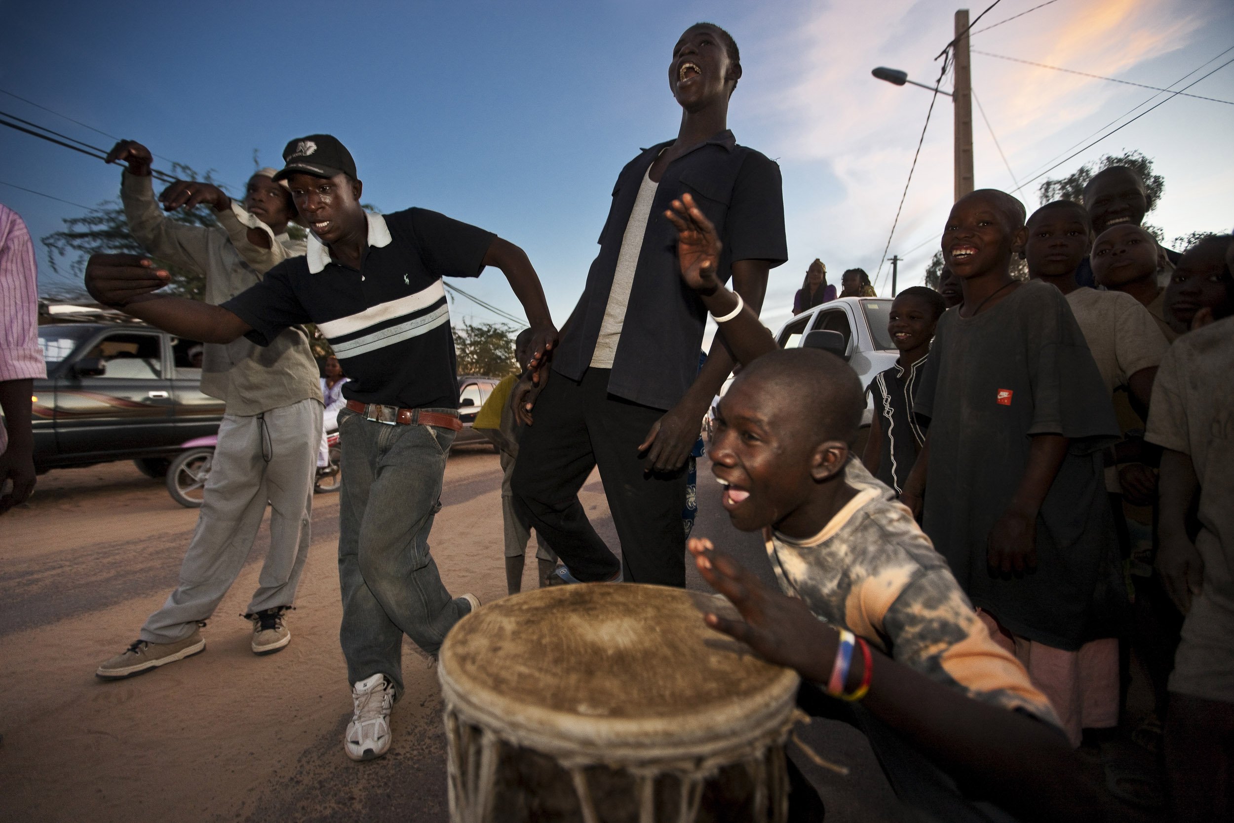 TIMBUKTU, MALI, JANUARY 2010:Young boys hired as drummers and dancers perform in the street outside a Songhay wedding taking place in a house nearby, Timbuktu, Mali, 10 January 2010. Dancing, music and celebration is unrestrained in Timbuktu, with l