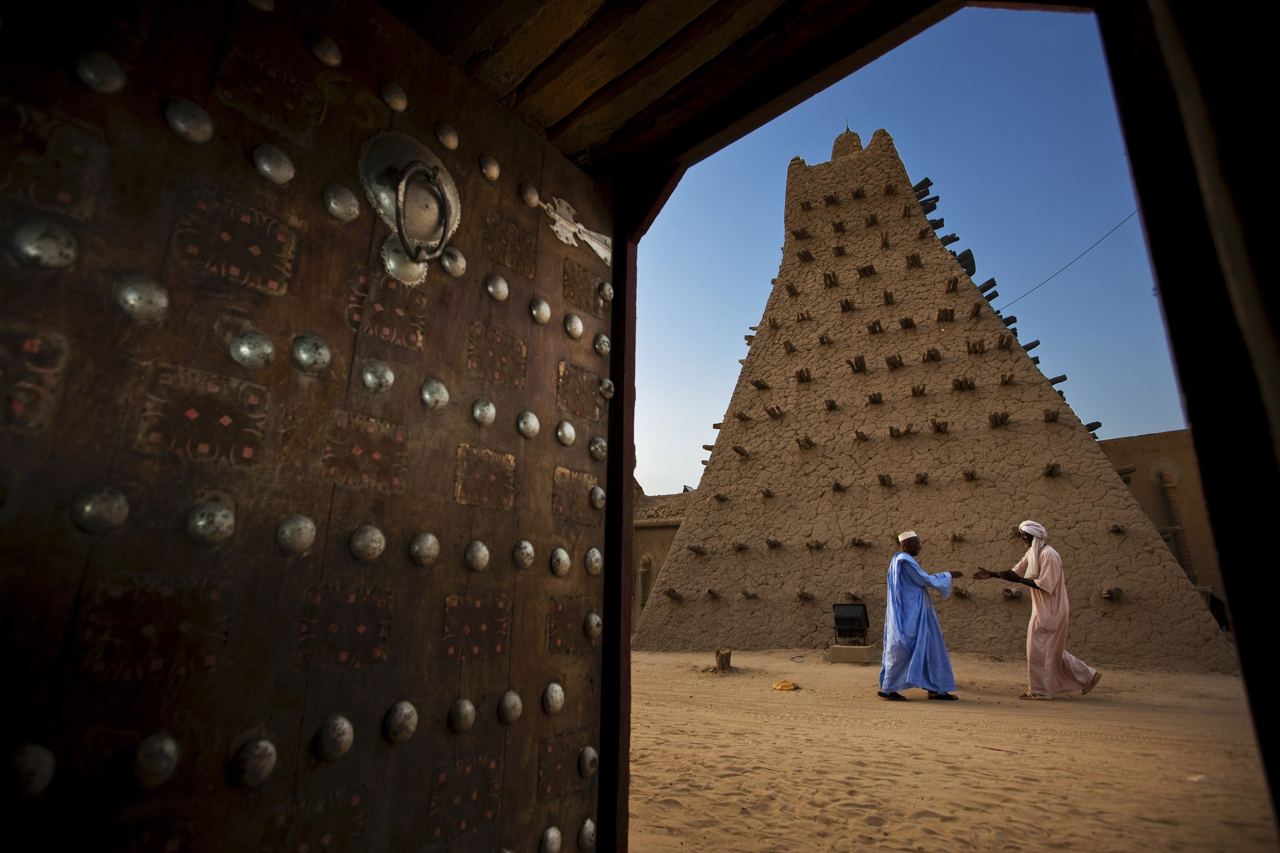 TIMBUKTU, SEPTEMBER 2009: Late afternoon street scenes around the Sankore Mosque as seen from a local residence with the famous Timbuktu door in evidence, Sankore is one of 3 mosques declared UNESCO sites in Timbuktu, a historical Malian city, a lon
