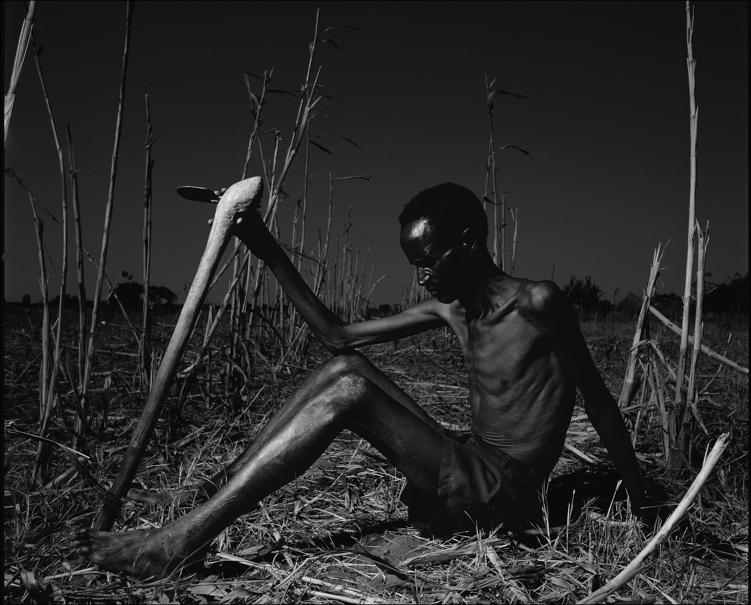 ZAMBIA: A malnourished farmer rests in his fields after harvesting what he could from his failed crop. The worst regional drought in one hundred years has crippled many farmers and starvation is a reality for these rural people. Climate change has b