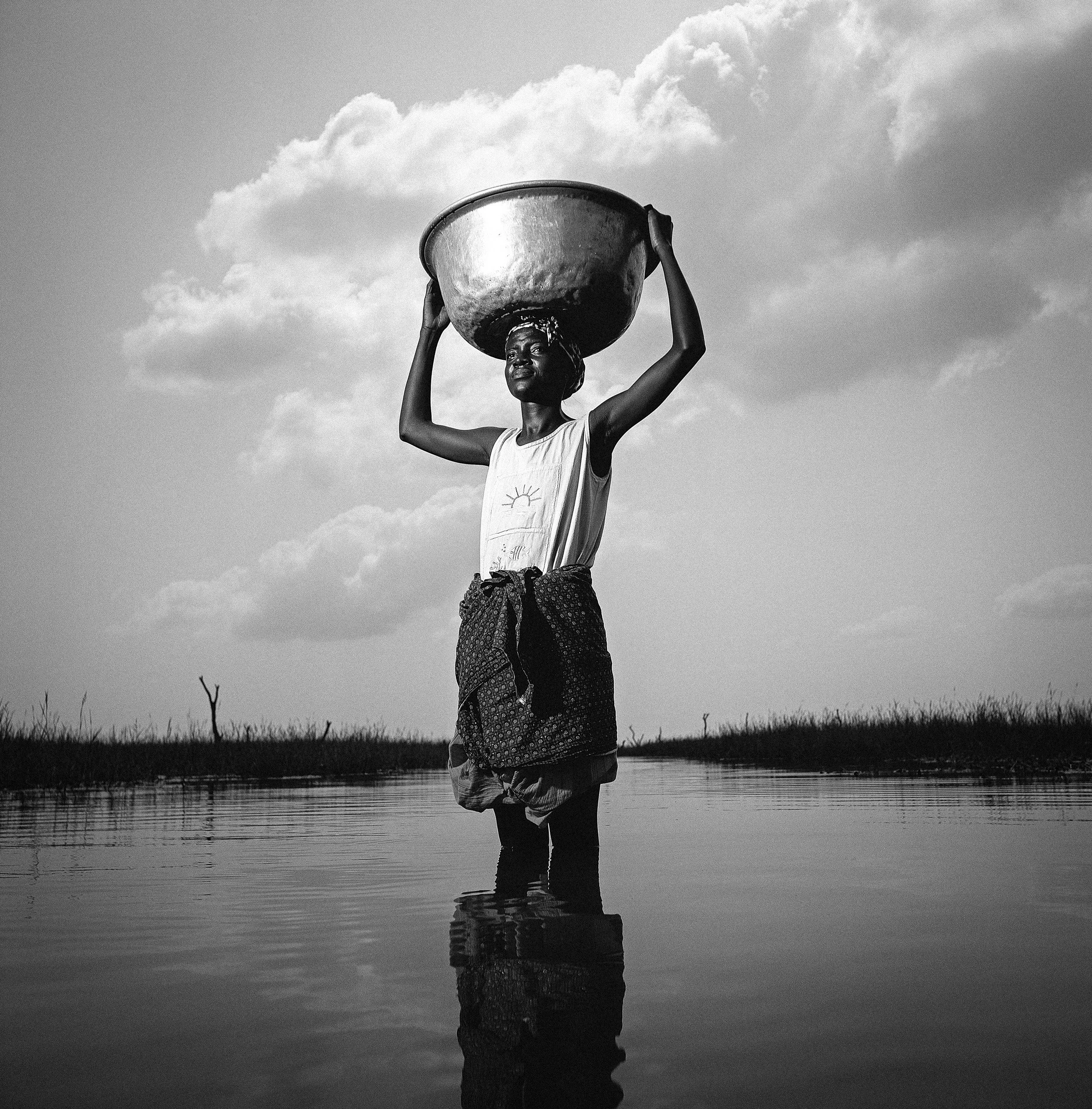 BOLGATANGA, GHANA: A young woman fetches water from a swamp area 4 miles from her village, she makes this trip at least once a day seven days a week. It takes a large part of her day and prevents her from other forms of employment, ongoing education