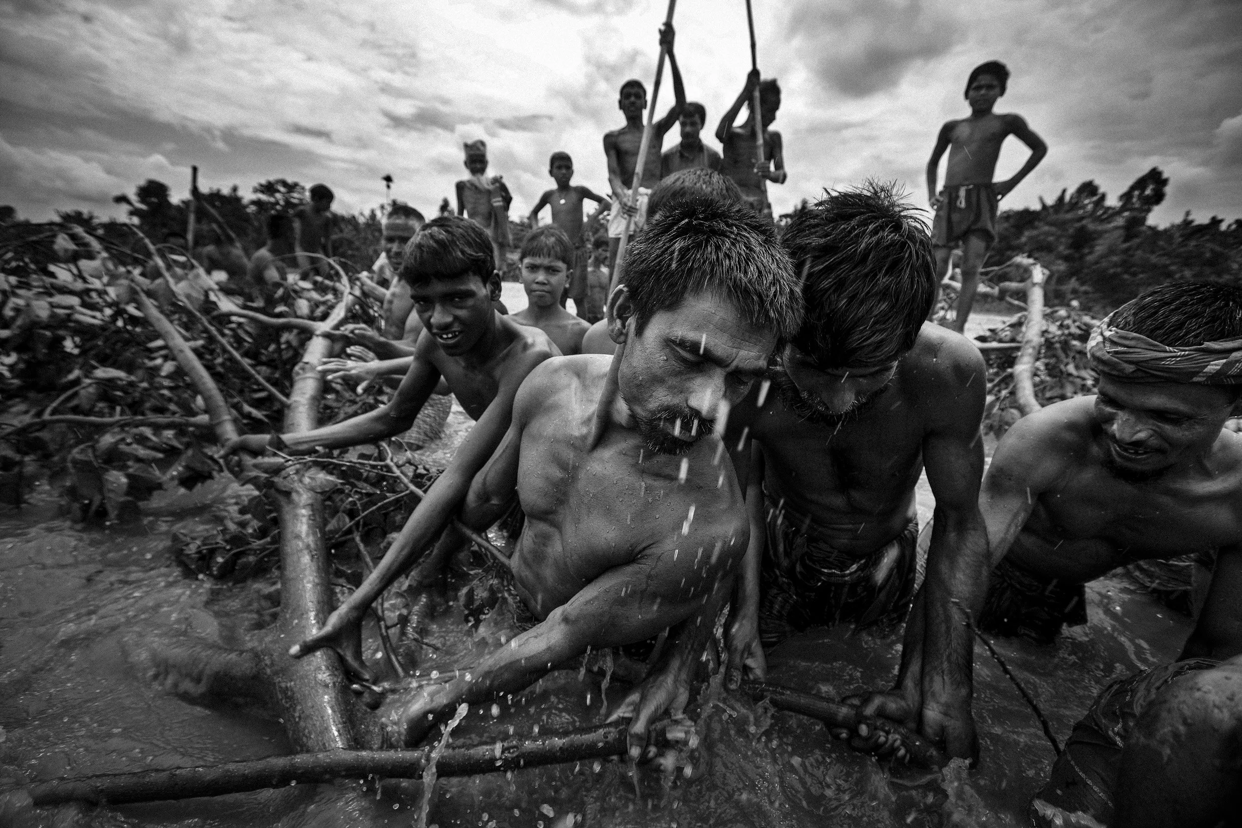 KURIGRAM, BANGLADESH: Village men clear debris from a flooded area so they can use their boats in the area where their village used to be, Kurigram, Northern Bangladesh, 2 August 2008. Flooding, Poverty and lack of protected land ownership amongst t