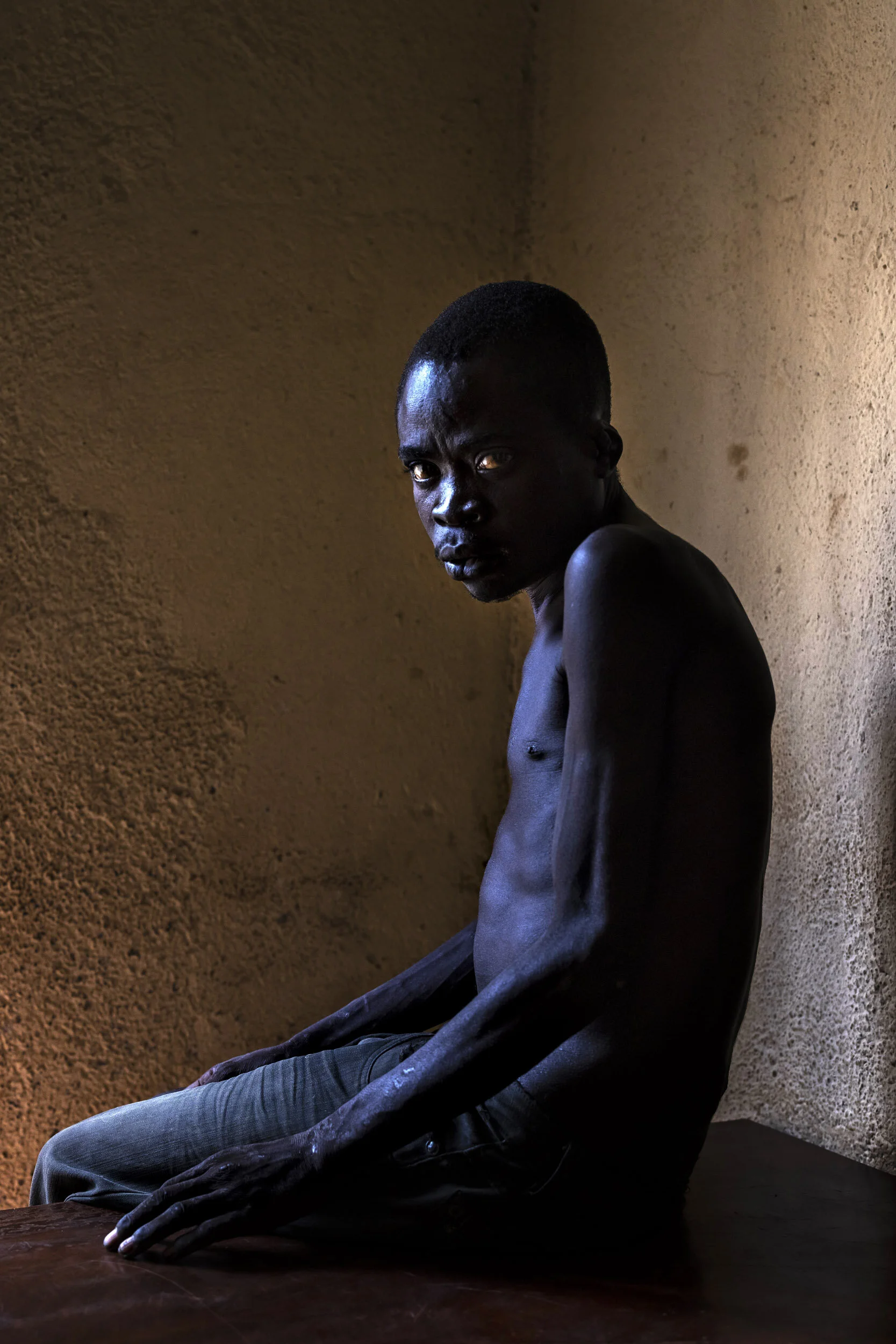 BENI, DEMOCRATIC REPUBLIC OF CONGO, 15 APRIL 2021: Bwambale Buwake Karibu, a young man from Uganda who authorities at Kangbayi Prison believe is a suspected ADF member. He was arrested in 2019 and displays signs of P.T.S.D. Many young male foreigne