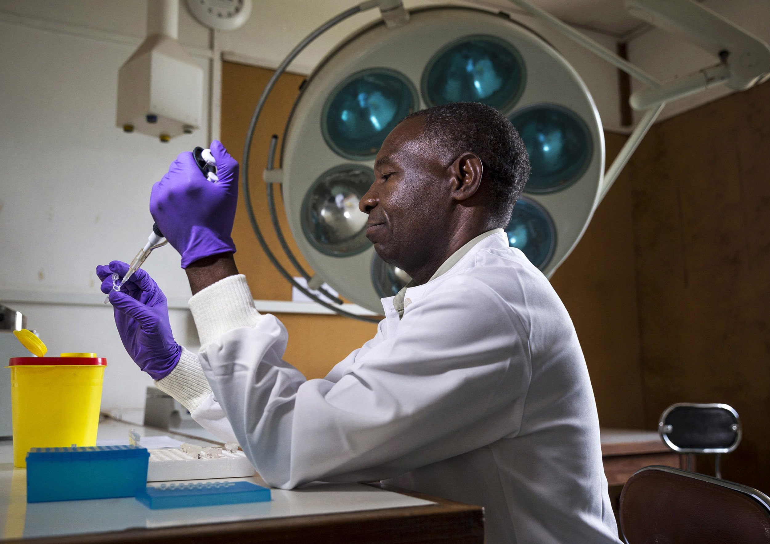 NDOLA, ZAMBIA, 16 JANUARY 2014: Researcher Eric M. Njunju prepares samples to identify the DNA strand of the Malaria pathogen at the Tropical Disease Research center at Ndola Central Hospital, Zambia. This technique is the most accurate manner by wh