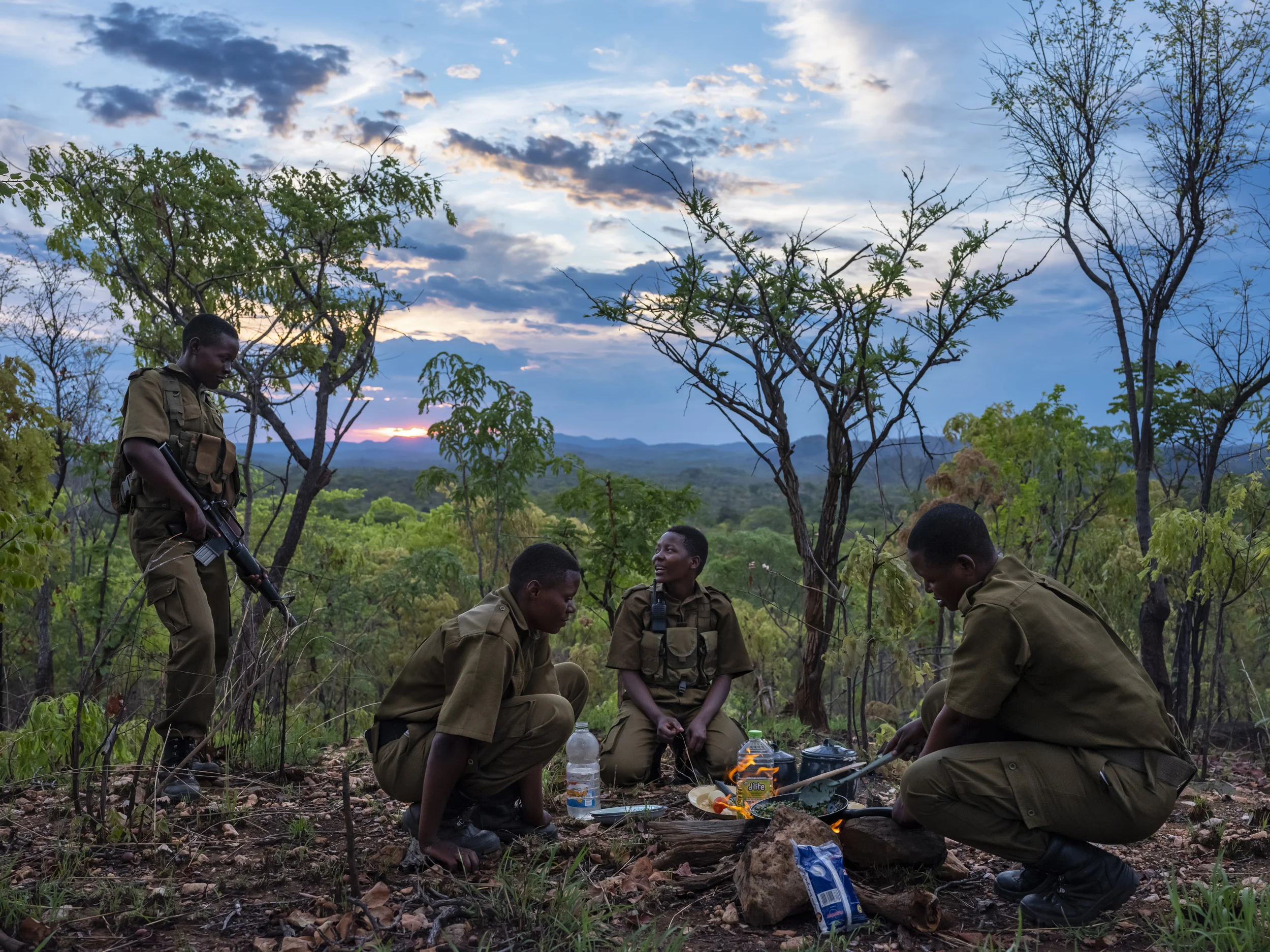 PHUNDUNDU WILDLIFE AREA, ZIMBABWE, DECEMBER 2018: A 5 member patrol cooks vegan food at an observation point in the wilderness they protect in Phundundu. This patrol is in the bush for 5 days at a time. They are part of an all female conservation ra