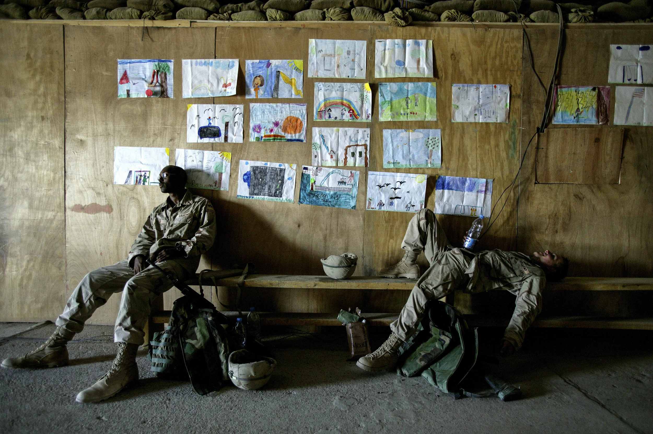 MAHMUYDIYAH,IRAQ - JUNE 7: Exhausted members of Bravo company, 1st Armoured Division, 6th Infantry relax after a long patrol in Mahmuydiyah. On the wall behind them are messages of support from children in the states, some belonging to the soldiers,
