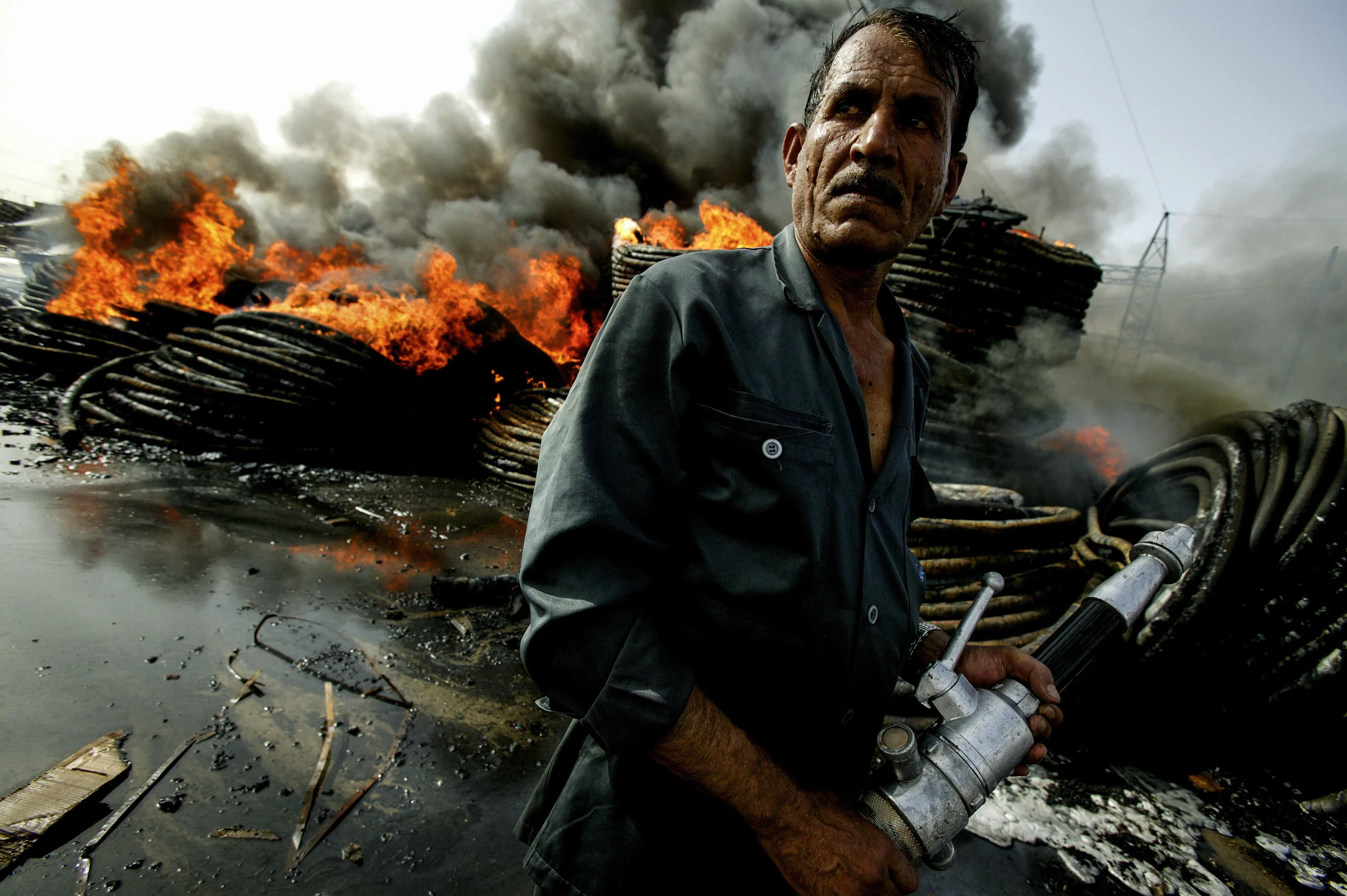BAGHDAD,IRAQ - MAY 10:The Baghdad Fire-Brigade works to put out a fire in the Al-Amriya district of Baghdad.The fire broke out after a bomb blast at a Electricity sub-station and destroyed a large stockpile of new electrical equipment. Disruptions t