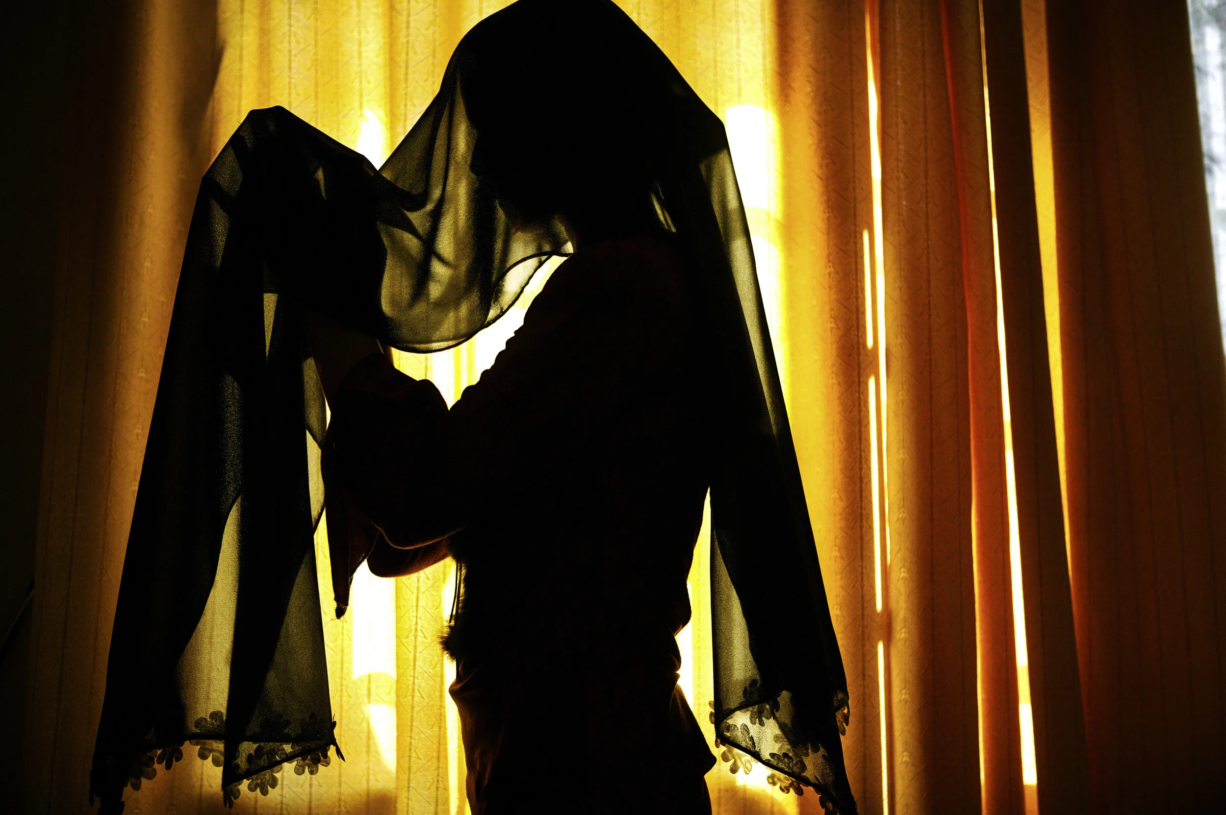 NAJAF, IRAQ-MAY 2004: A young girl prepares to wear her Abaya full covering dress for the first time as she goes to pray in Najaf, the holiest city in Iraq for Shiites. PHOTO BY BRENT STIRTON/GETTY IMAGES