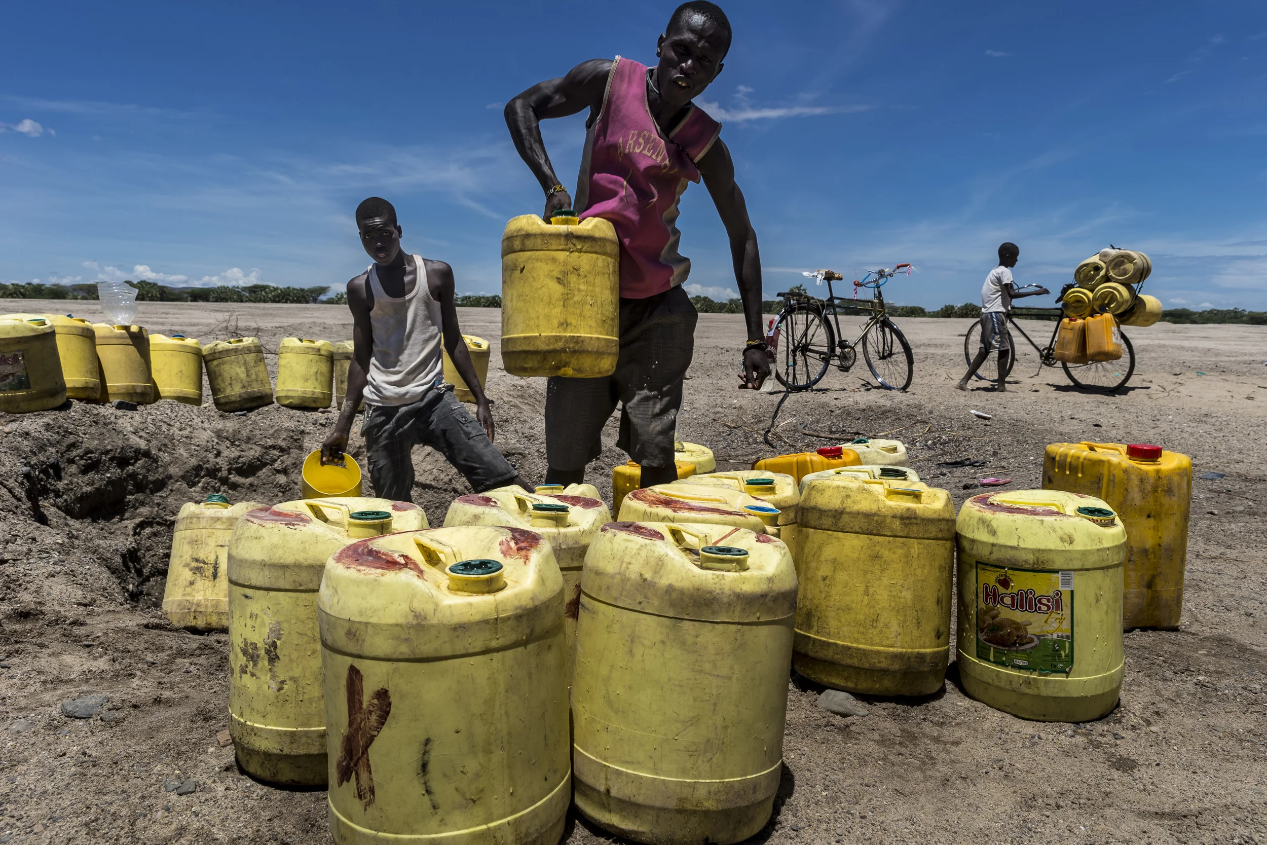 TURKANA, KENYA, 8 OCTOBER 2014: Boys collect water from a dry river bed to sell it in the nearby town of Karokol, Lake Turkana, Kenya. The water is sold for around 20 Kenyan Shillings for 20 Gallons. The town does not have running water and most wat