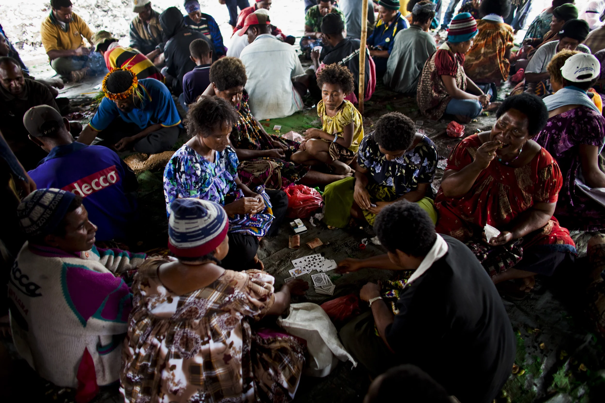 MOUNT HAGEN, HIGHLANDS, PAPUA NEW GUINEA-DECEMBER 2008: Scenes of highland people gambling in large groups at a local roadside market in Mount Hagen, Papua New Guinea, 16 December 2008. People sell beetle-nut, vegetables, cigarettes at this market a