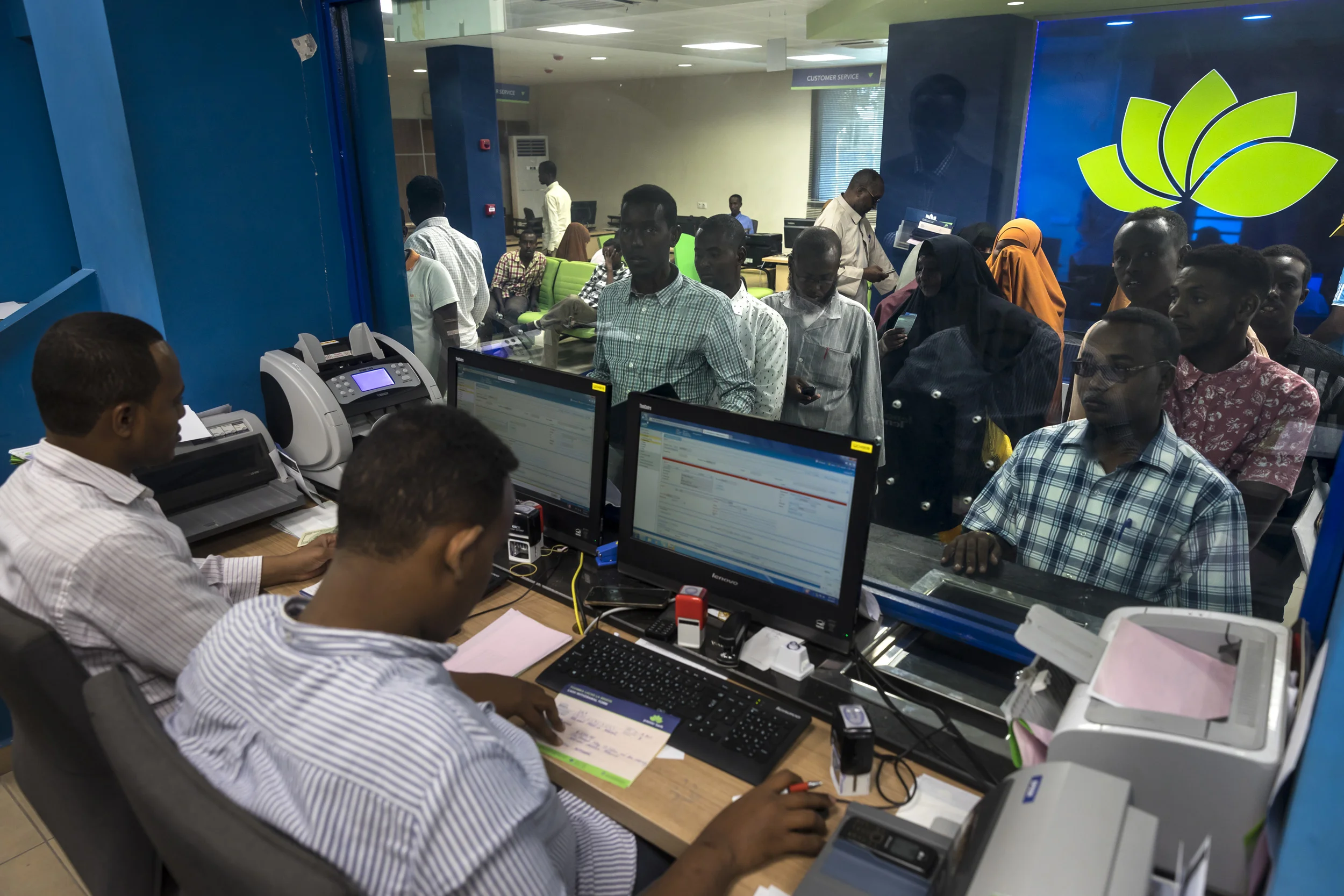 MOGADISHU, SOMALIA, 5 AUGUST 2017: Customers doing brisk business inside Premier Bank in Mogadishu. This modern bank has 6 branches in Mogadishu and 1 in Hargeysa. 70% of all banking is done by phone in Somalia and is done in dollars. The lack of a