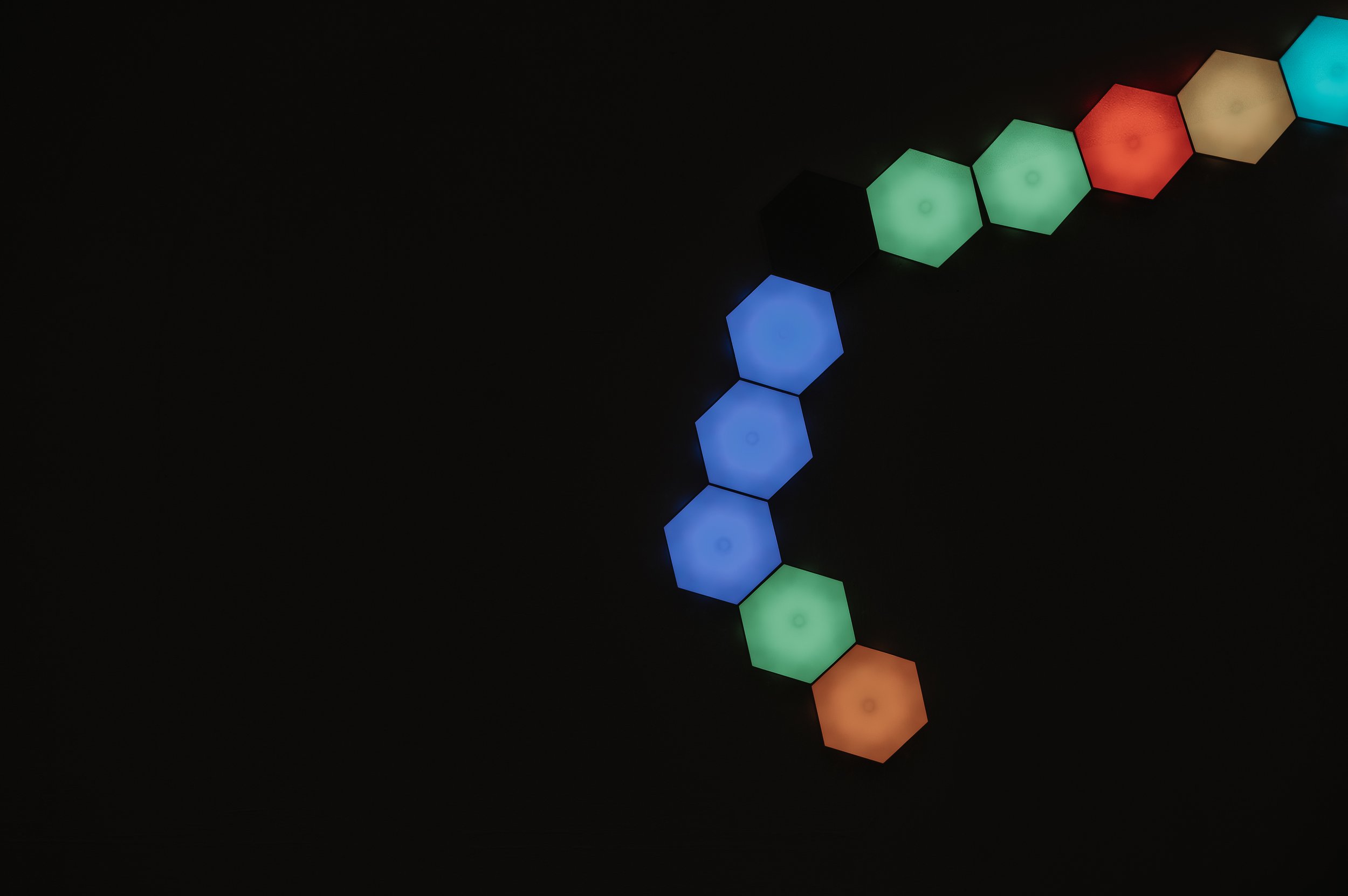 Colorful hexagonal LED lights in green, blue, red, orange, and teal on a black background.