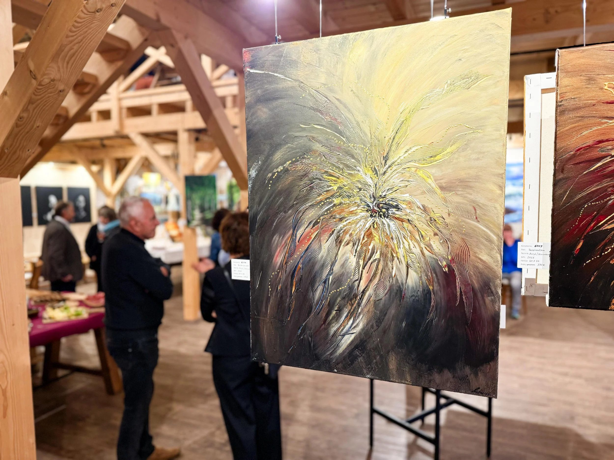 Abstraktes Gemälde mit Explosion aus hellen, cremigen und dunklen Farben, das in einem Kunstgalerie-Ausstellung gezeigt wird, umgeben von mehreren Betrachtern.