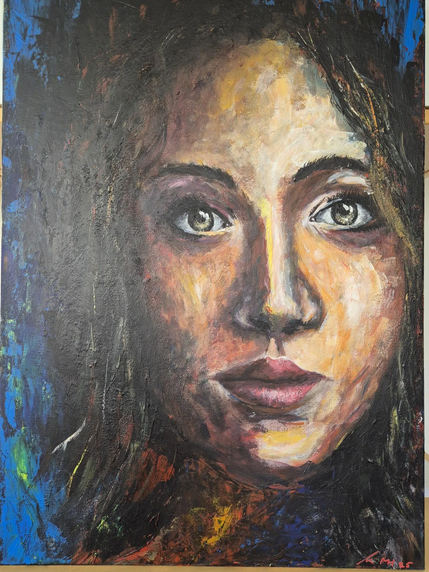 Ein farbenfrohes Porträt einer jungen Frau mit blauen und grünen Akzenten auf der linken Seite, dunklen Haaren und ausdrucksstarken Augen.