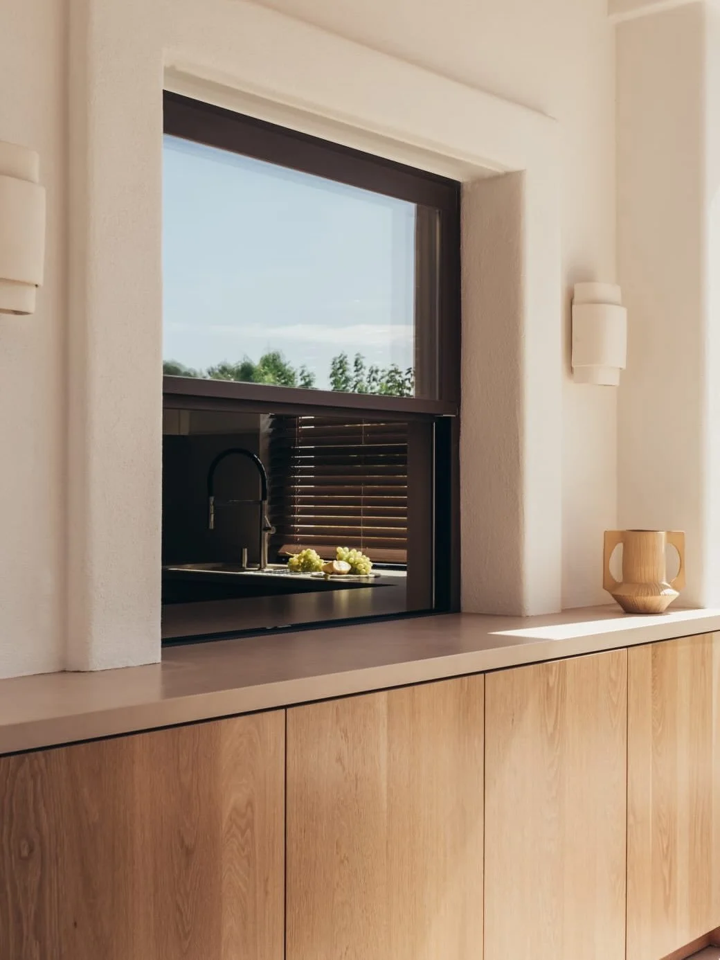 El porche est&aacute; pensado como una extensi&oacute;n natural de la vivienda, un espacio donde la vida transcurre sin prisa entre interior y exterior.

En Can Pedra las vigas vistas, la madera y los detalles en fibras naturales como la rafia aporta