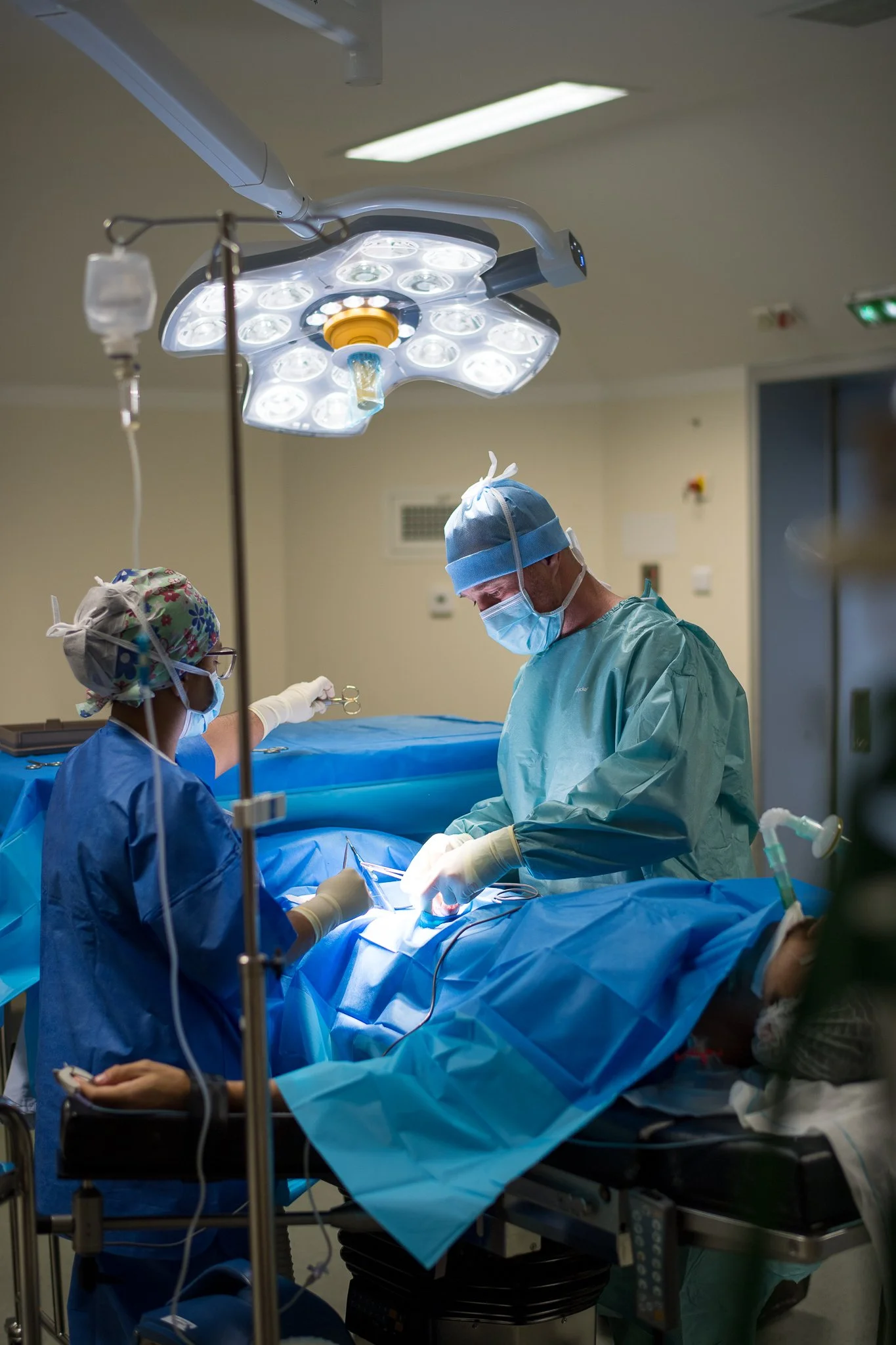 Une équipe de chirurgiens en pleine opération dans une salle d'opération, sous un éclairage médical brillant.