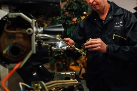 Person working on a mechanical device with tools in hand.