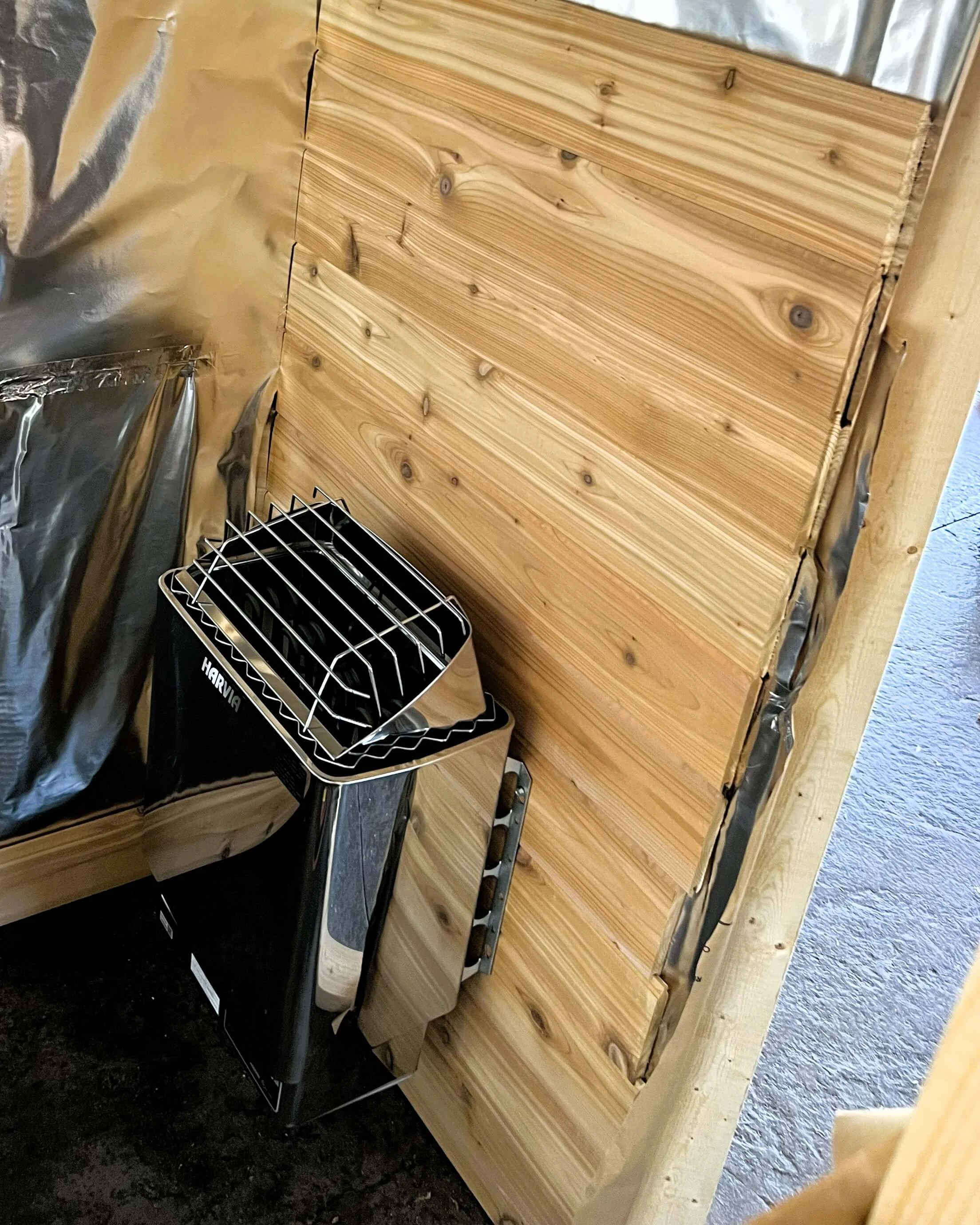 6kW Harvia electric sauna heater installed inside custom cedar sauna for consistent heat and smooth steam performance.