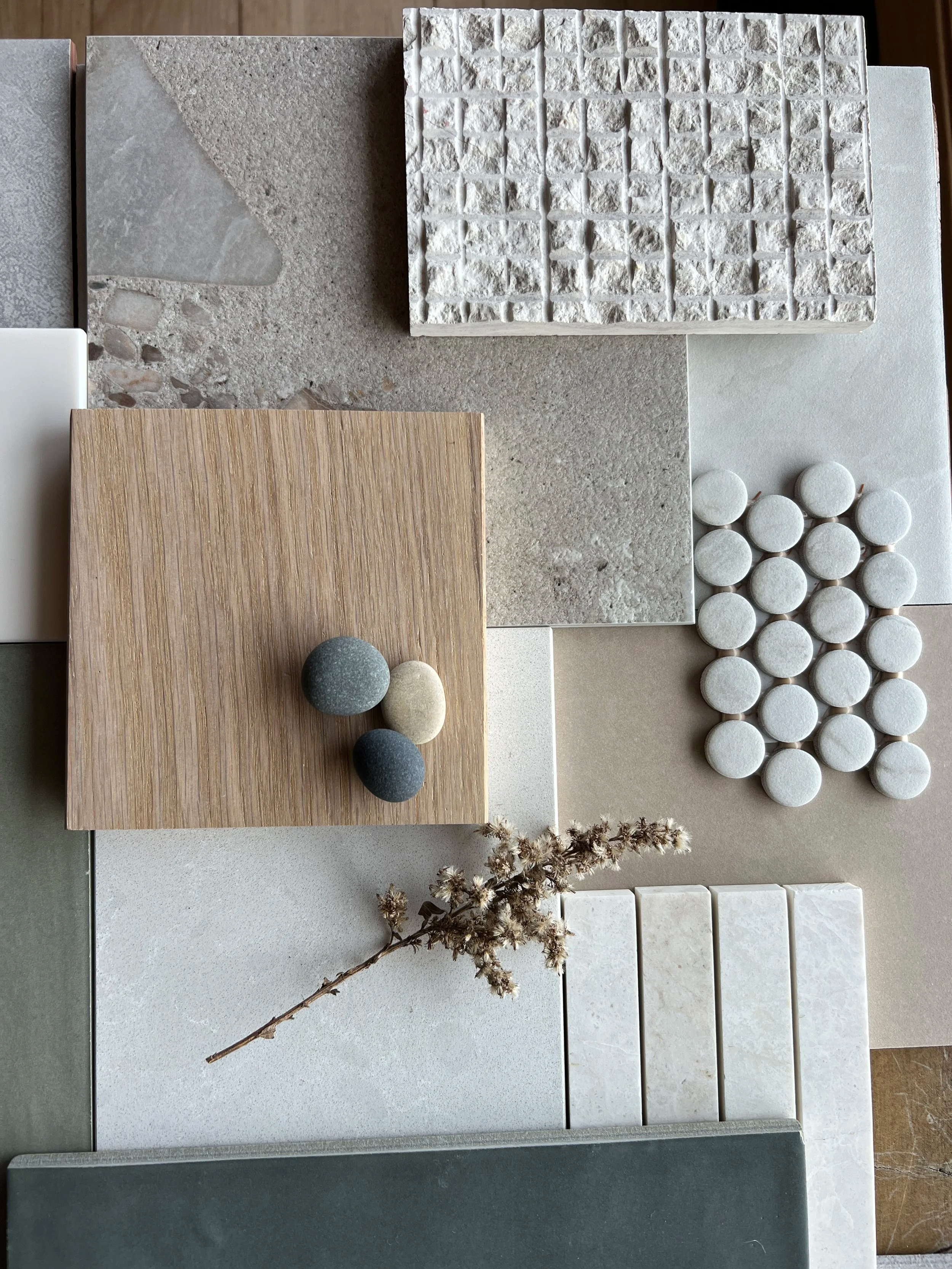 An assortment of various textured surface samples including tiles, stones, and wood, arranged on a display board.