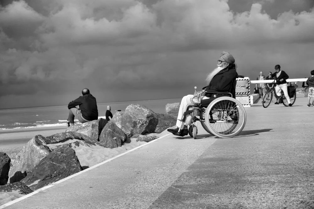 Hintergrundbild Mann im Rollstuhl vor Meer