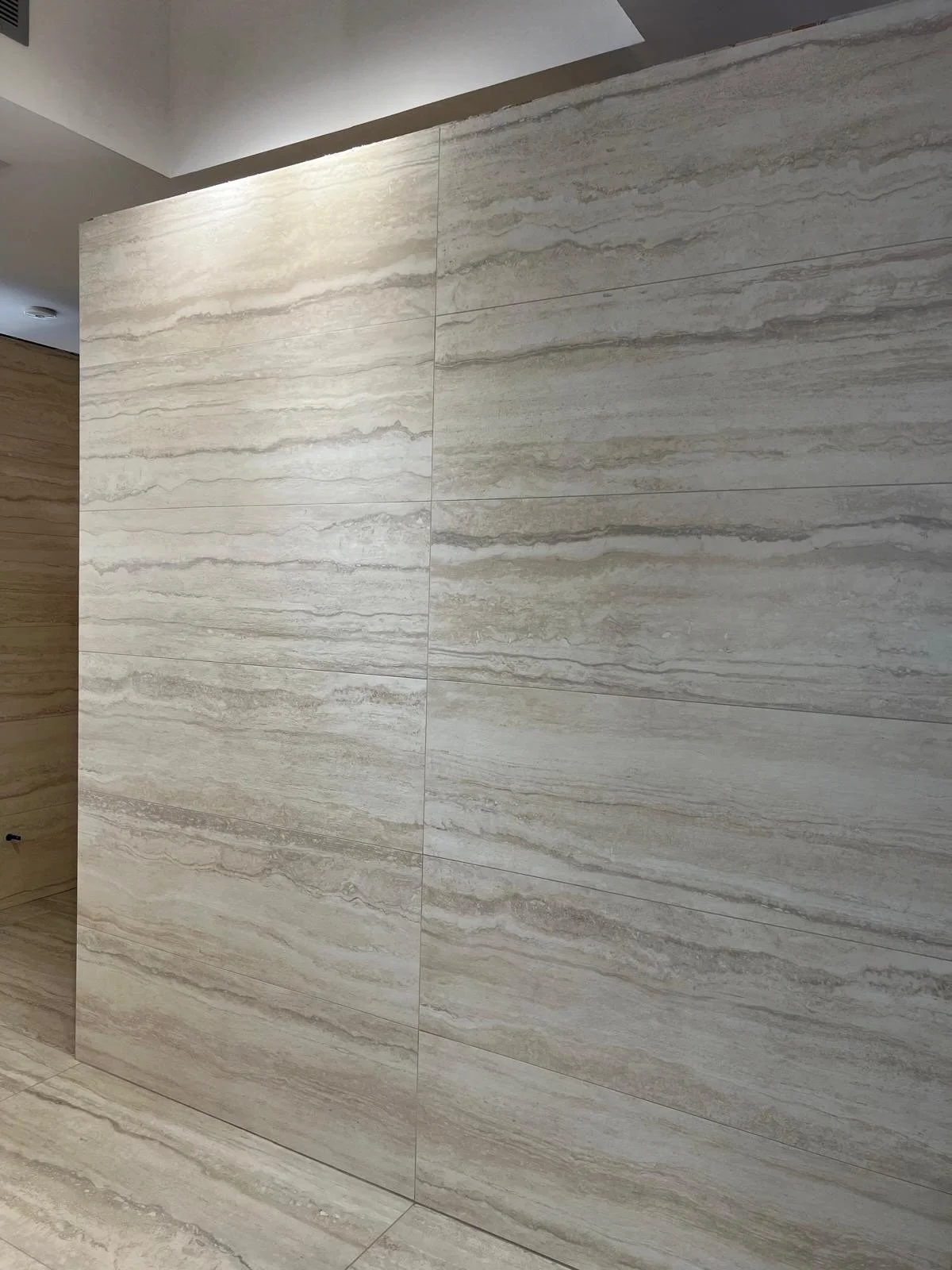 Image of a beige stone or tile wall interior with horizontal natural patterning.