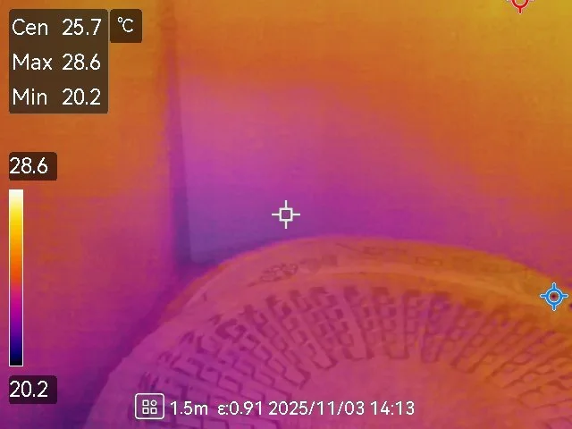 Thermal image of a baseball on a floor near a corner, showing temperature ranges from about 20.2°C to 28.6°C.