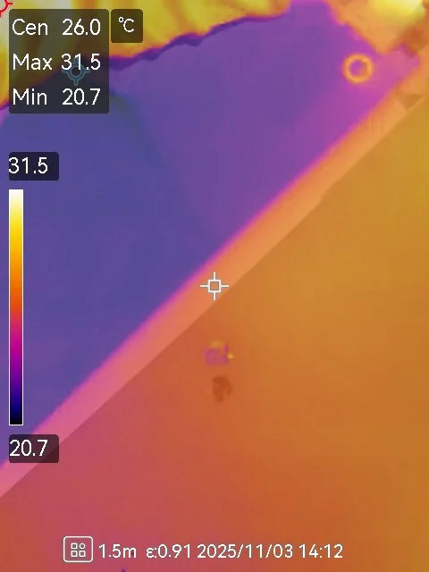 Infrared thermal image showing a surface with temperature readings from 20.7°C to 31.5°C, with a color gradient from purple to orange, and a small object emitting heat near the top right corner.