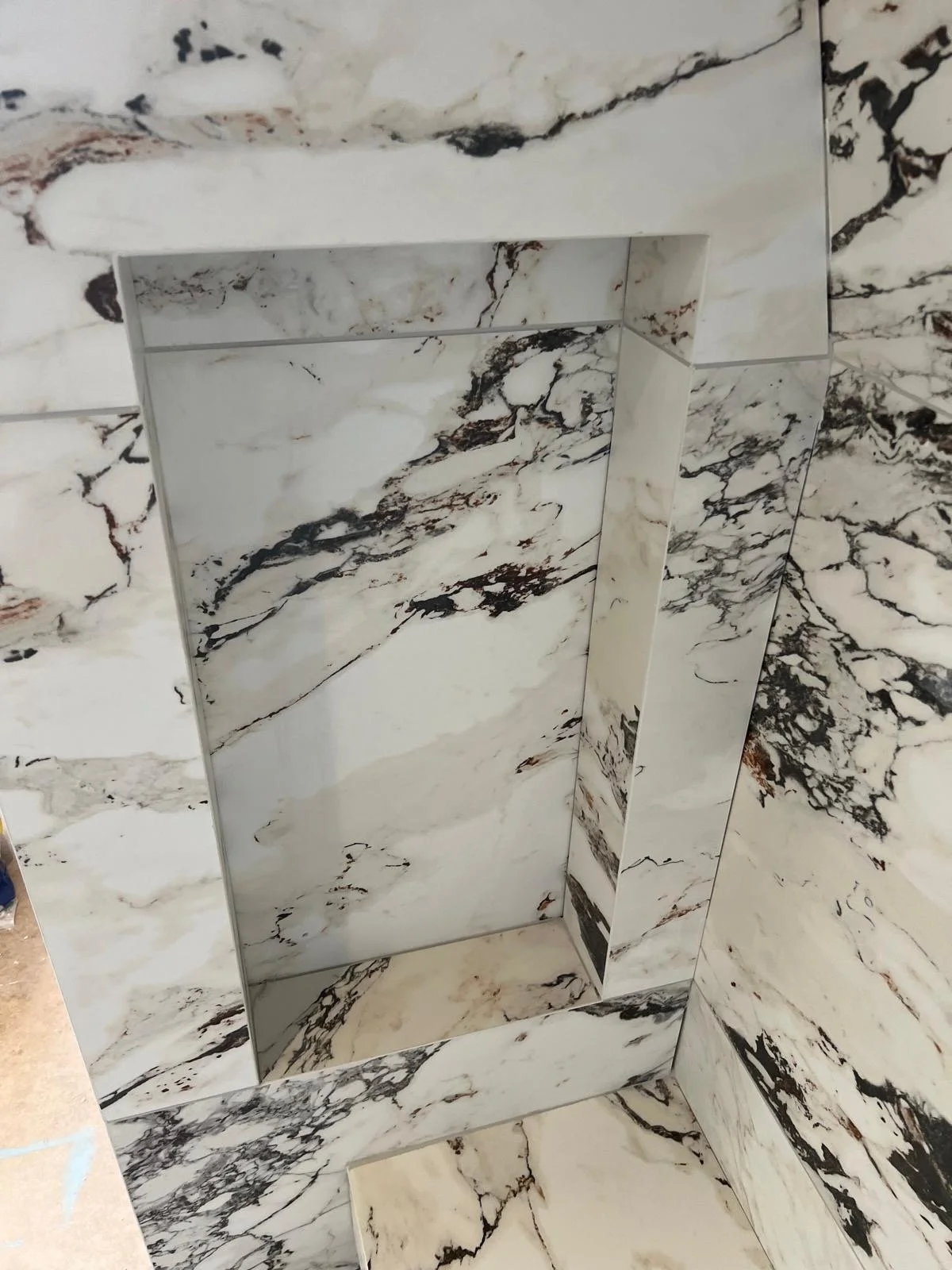 Marble-clad elevator with matching marble walls, floor, and ceiling.
