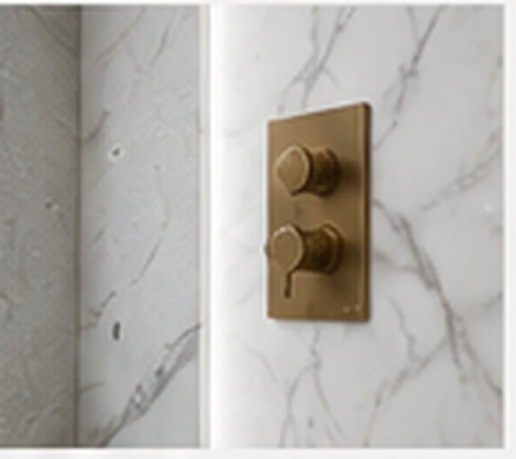 Precision bathroom finishing detail with brushed brass controls and marble-effect surface