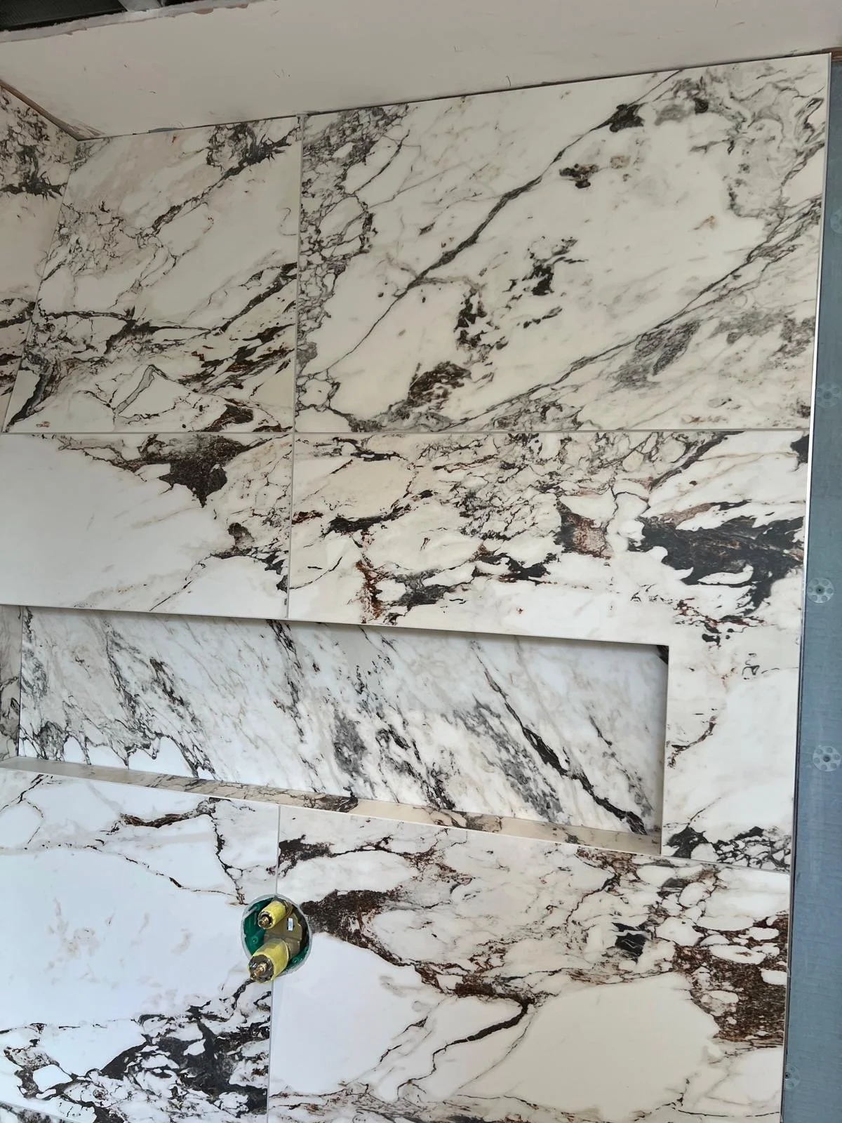 A wall with marble tiles featuring white and black veining patterns.
