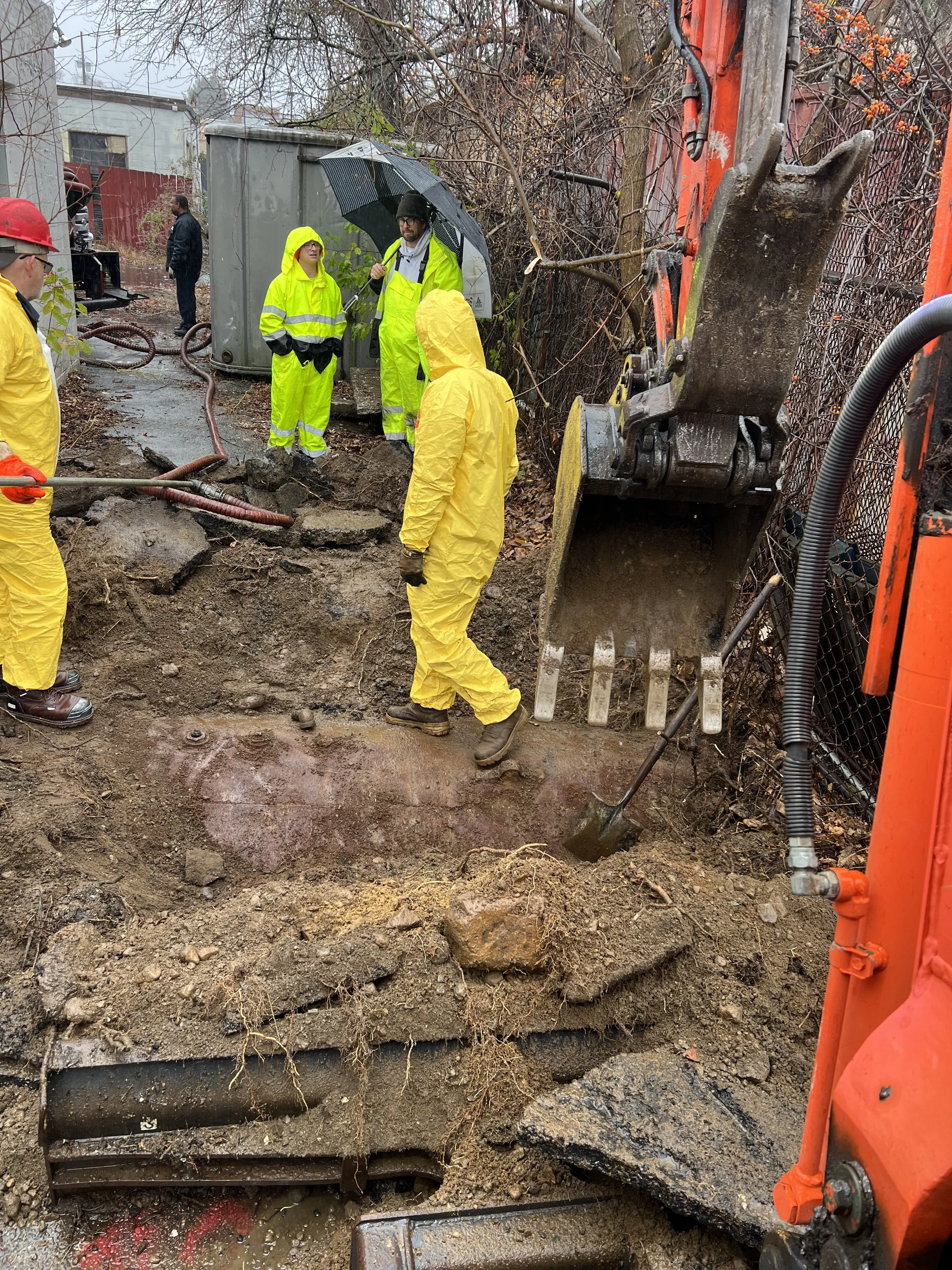 removing and cleaning an underground oil tank from an old building with an excavator
