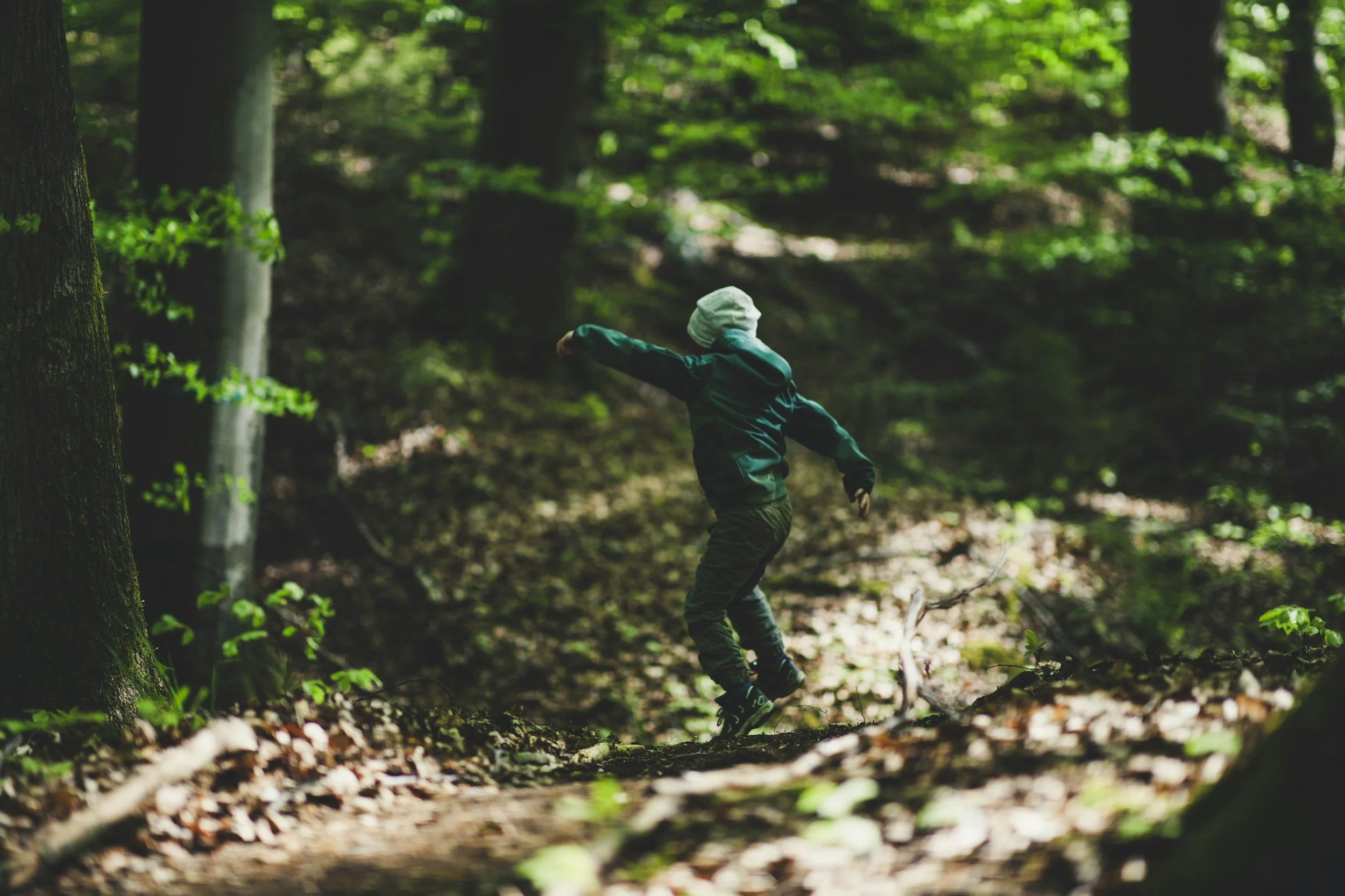 Niño jugando entre los árboles de un bosque