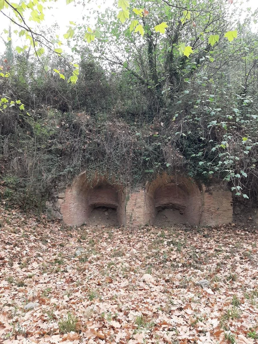 Dos bocas de los antiguos hornos de cemento de Campins, rodeadas de bosque y hojas