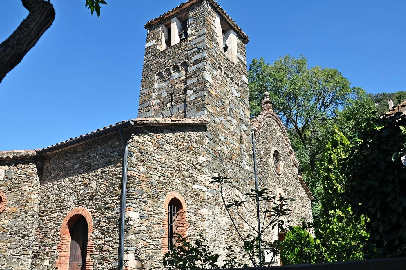 Campanario y muros de piedra de la iglesia de Sant Julià en Montseny pueblo