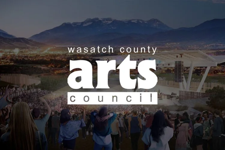 An outdoor concert with a large crowd in Wasatch County, with mountains in the background, promotional overlay for Wasatch County Arts Council.