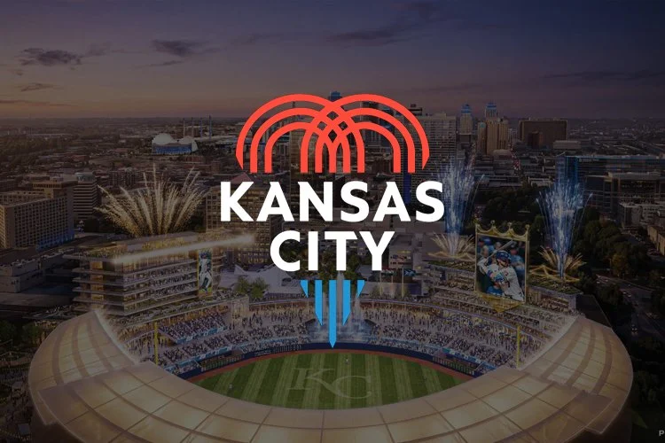 Aerial view of Kansas City sports stadium at sunset with fireworks; Kansas City logo with red, white, and blue design in the foreground.